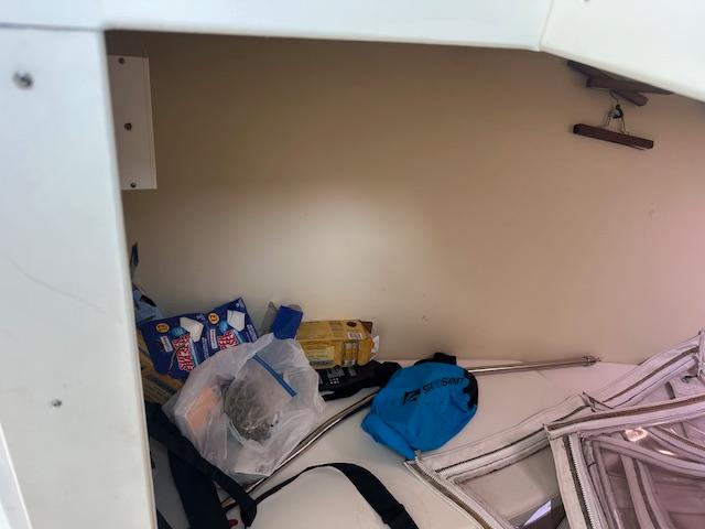 Storage area inside a 2011 Custom Carolina 26 boat with various items and supplies.