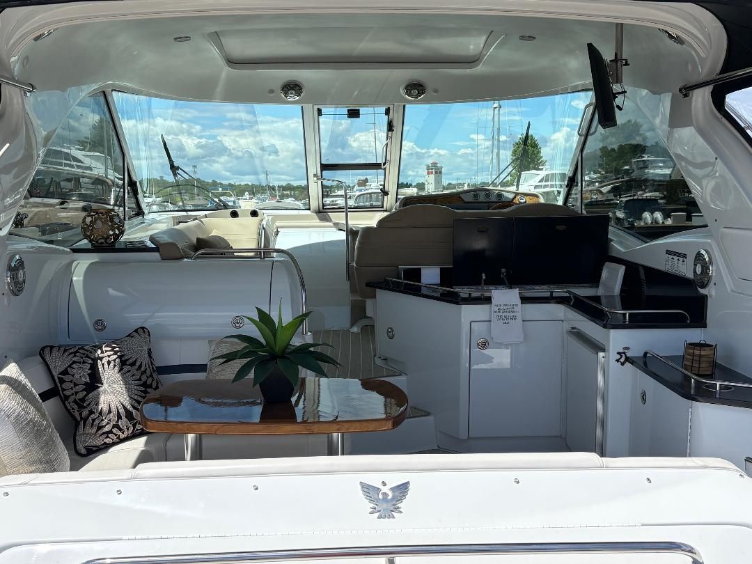 Interior of a 2011 Formula 45 with elegant seating area, table, and plants. Large windows offer views.
