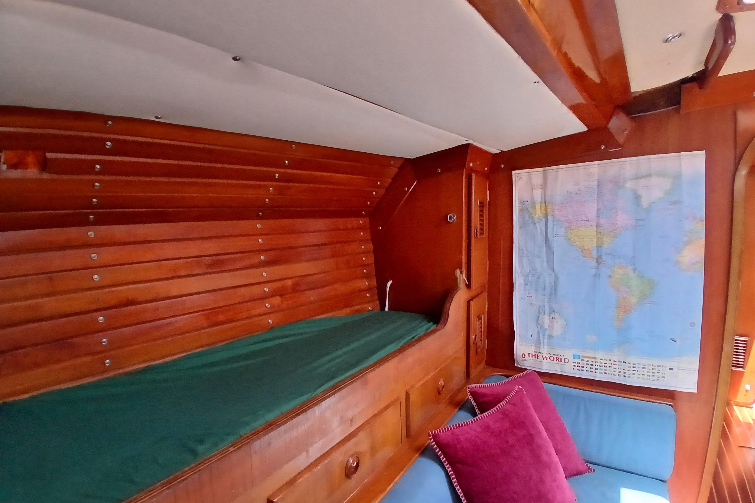 Interior of 1981 SKYE 51 yacht with wooden paneling, world map, and cozy seating.