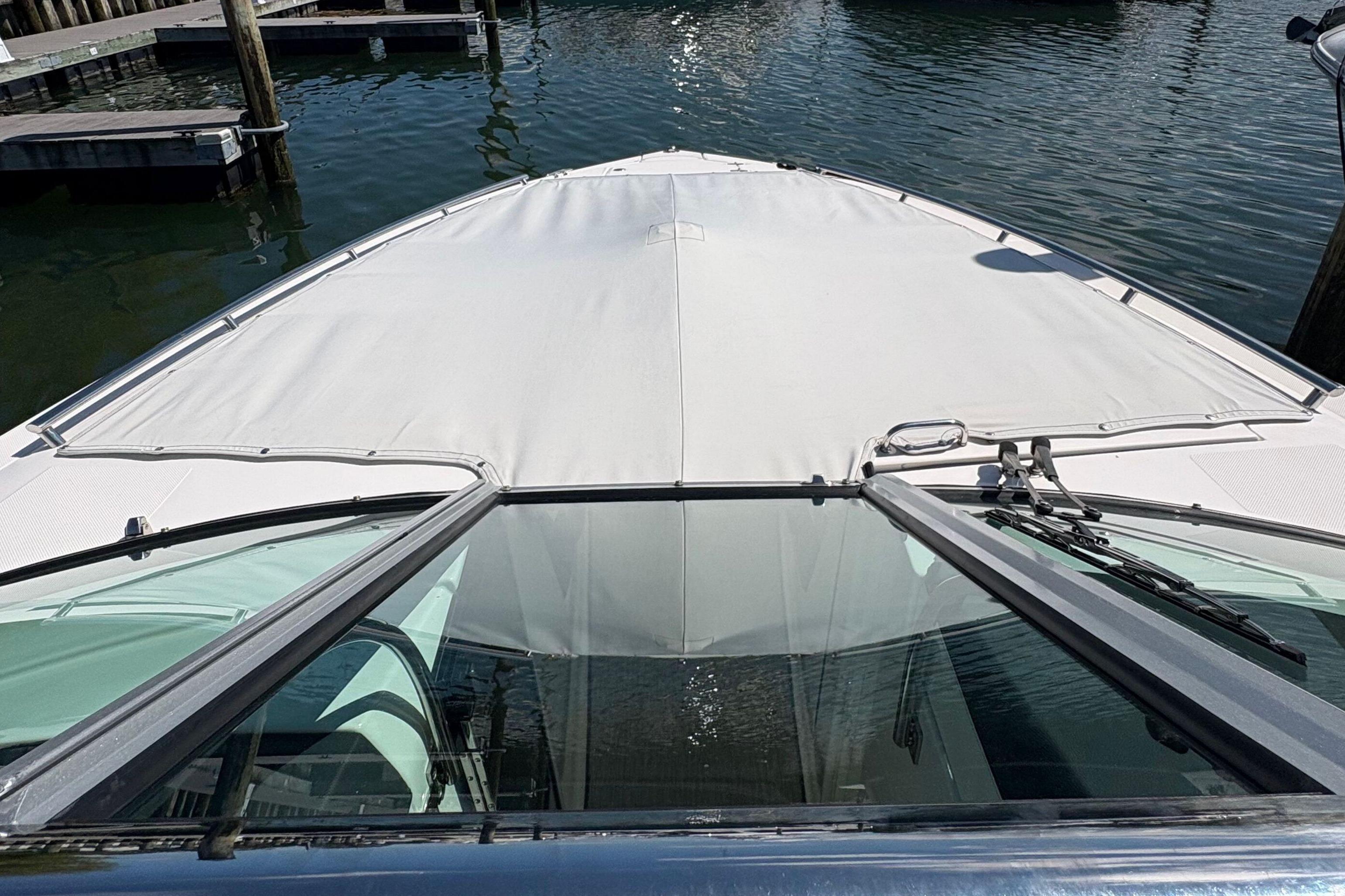 2020 Regal 33 OBX boat docked, view from the bow with water in the background.