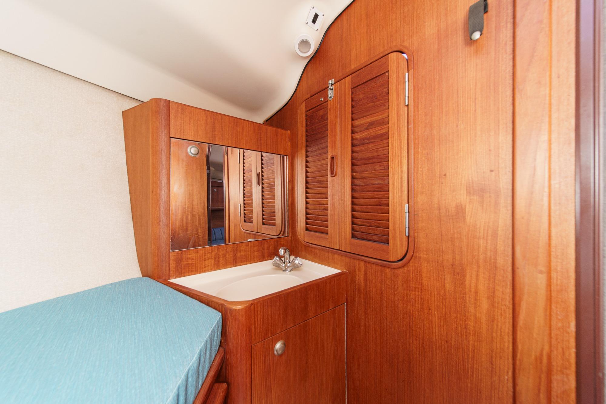 Interior of 1996 Hunter 376 sailboat with wooden cabinetry and compact sink area.