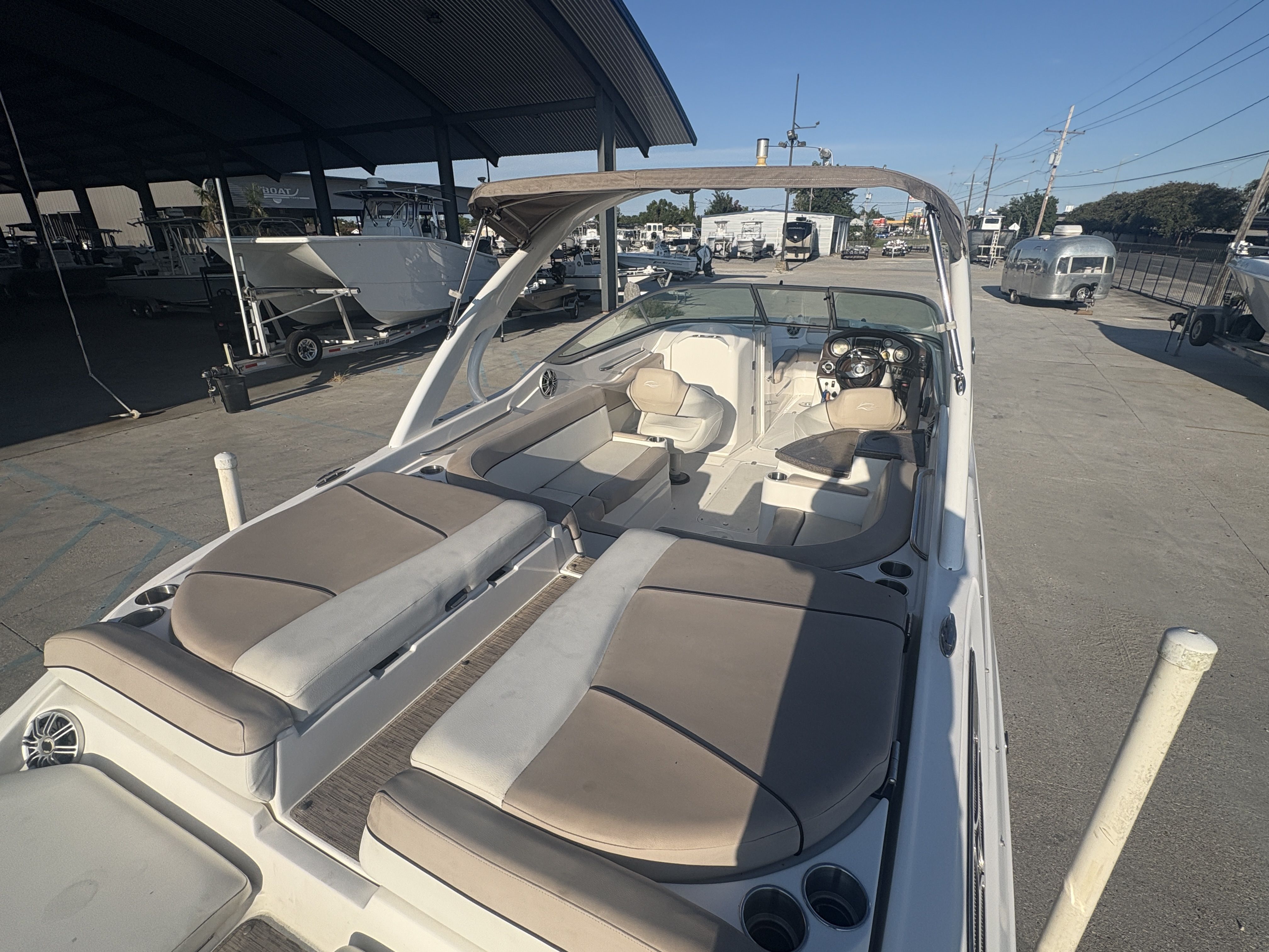 2013 Rinker Captiva 276 boat with spacious seating and modern dashboard, docked outdoors.