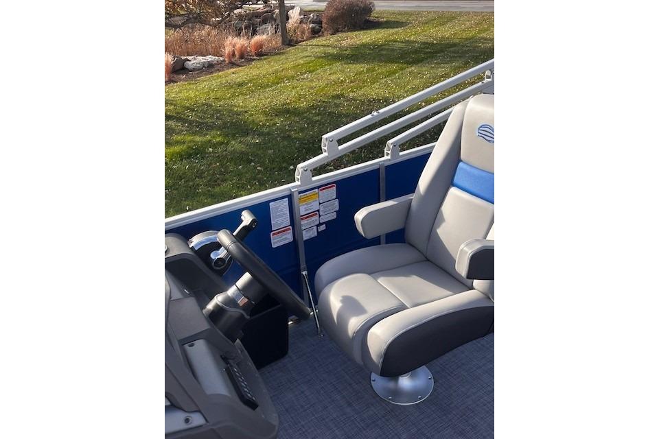 2026 Sun Tracker Party Barge 20 DLX interior with captain's chair and steering wheel.