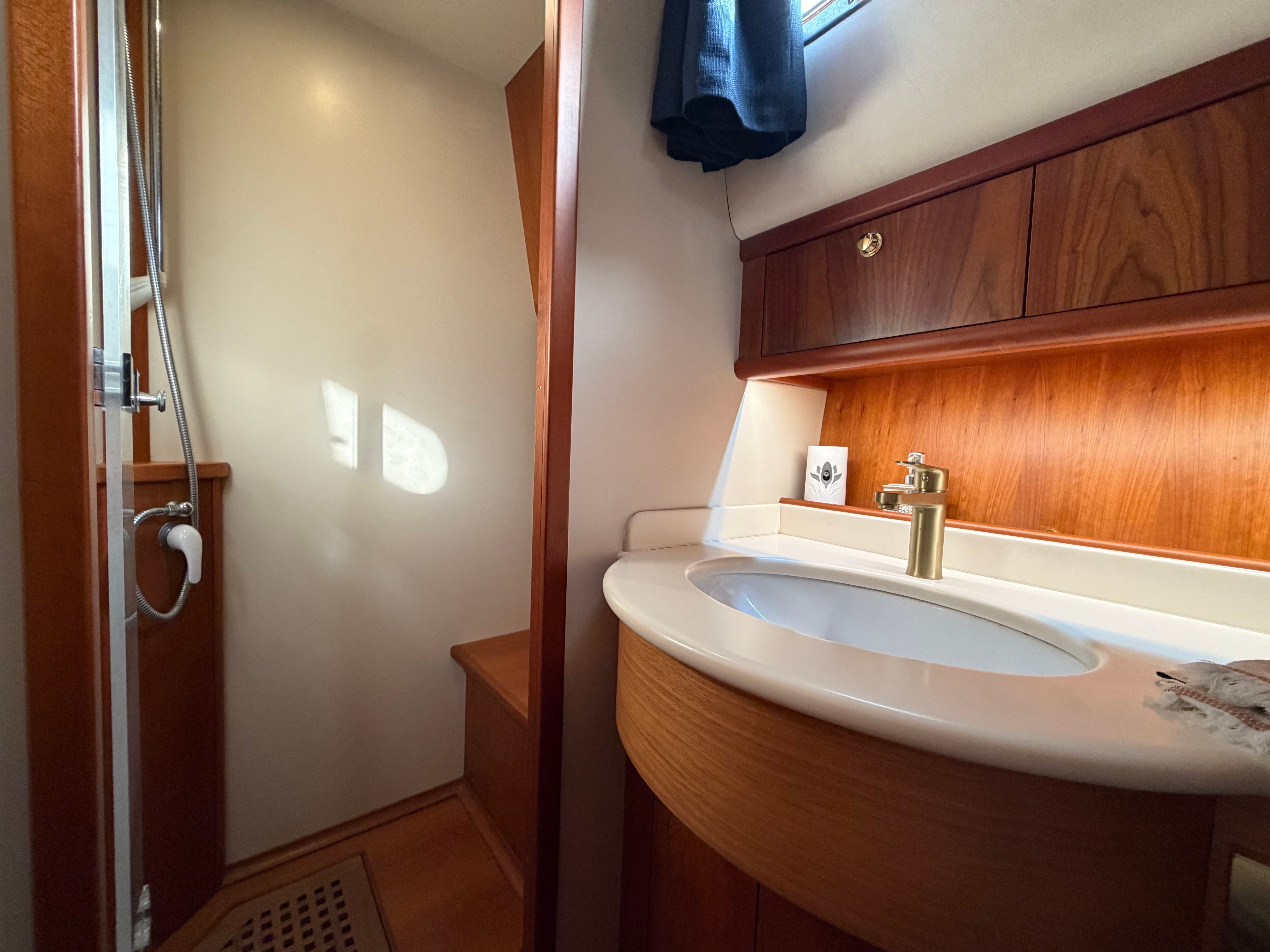 The image shows an elegant bathroom with wood paneling and a sink.