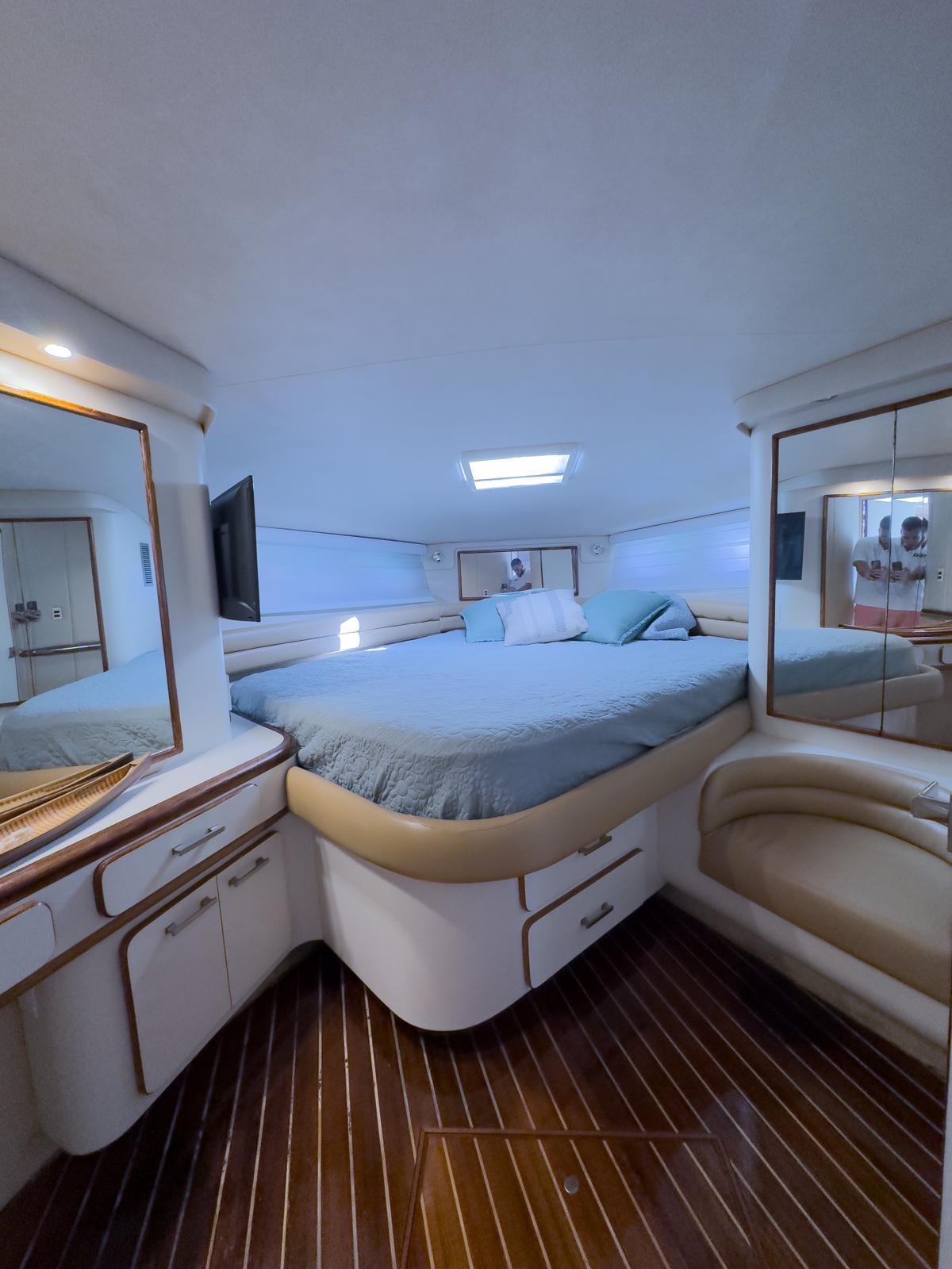 Luxurious 1994 Sea Ray 500 Sundancer cabin with elegant wood flooring and cozy bedding.