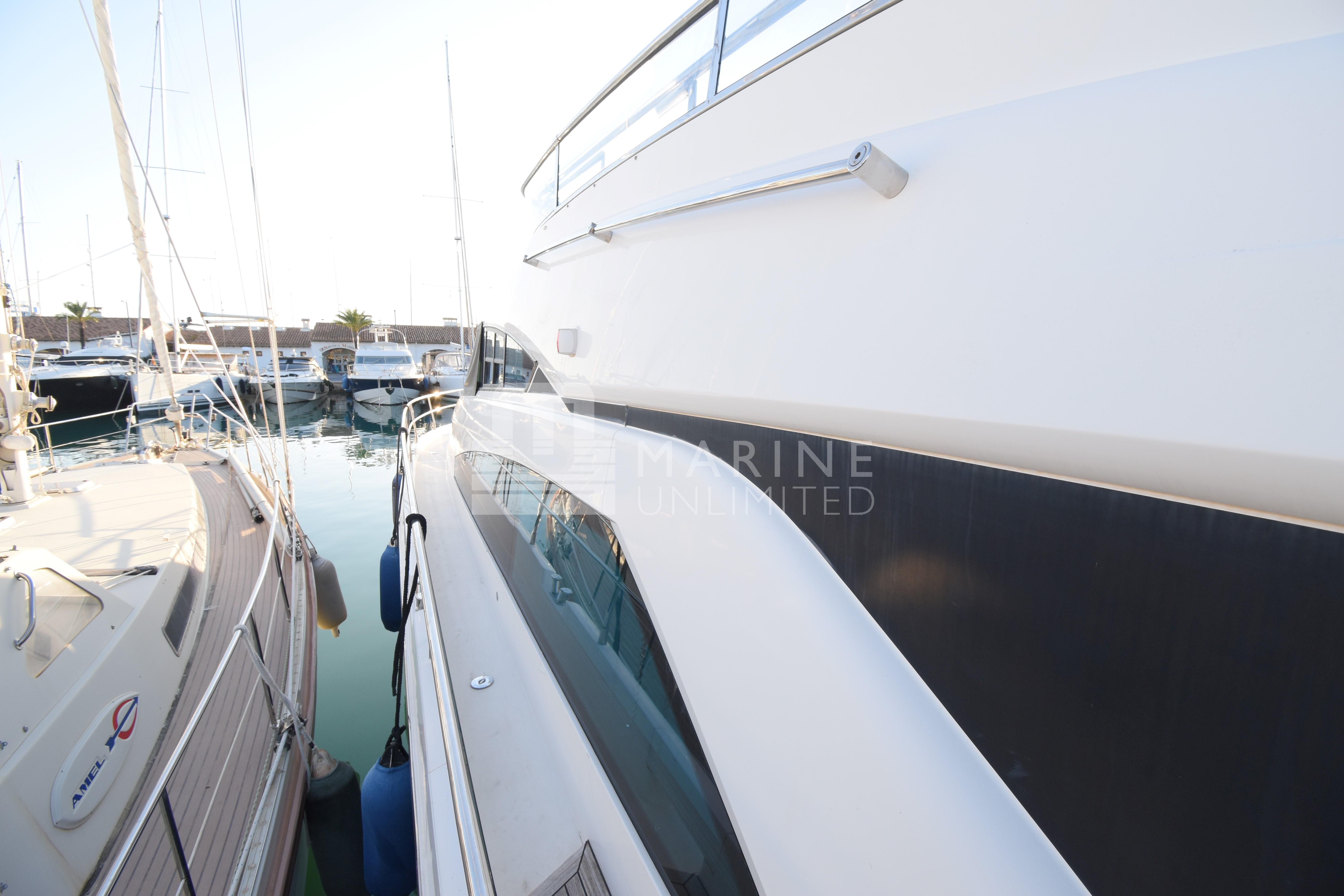 2010 Fairline Squadron 55 yacht docked in a marina, side view.