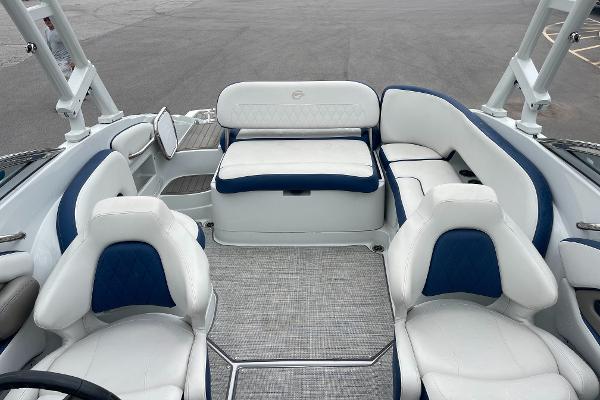 2023 Crownline E235 boat interior with white and blue seating, spacious layout.
