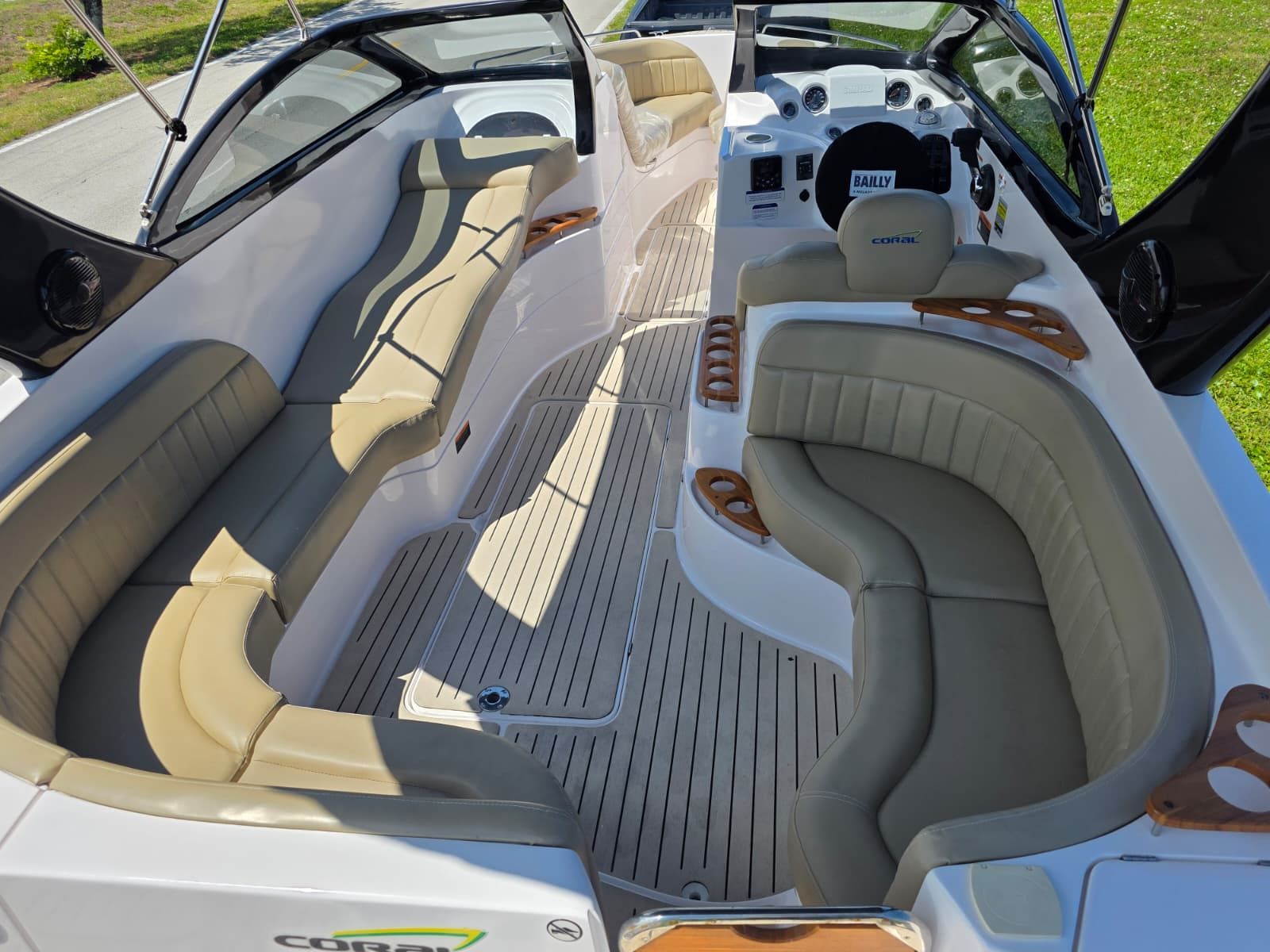 The image shows the interior of a Coral 26 boat with beige leather seating and wood accents.