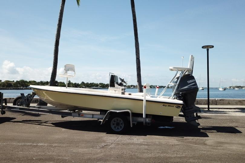 2002 Key West 1760 Stealth boat on trailer by waterfront.