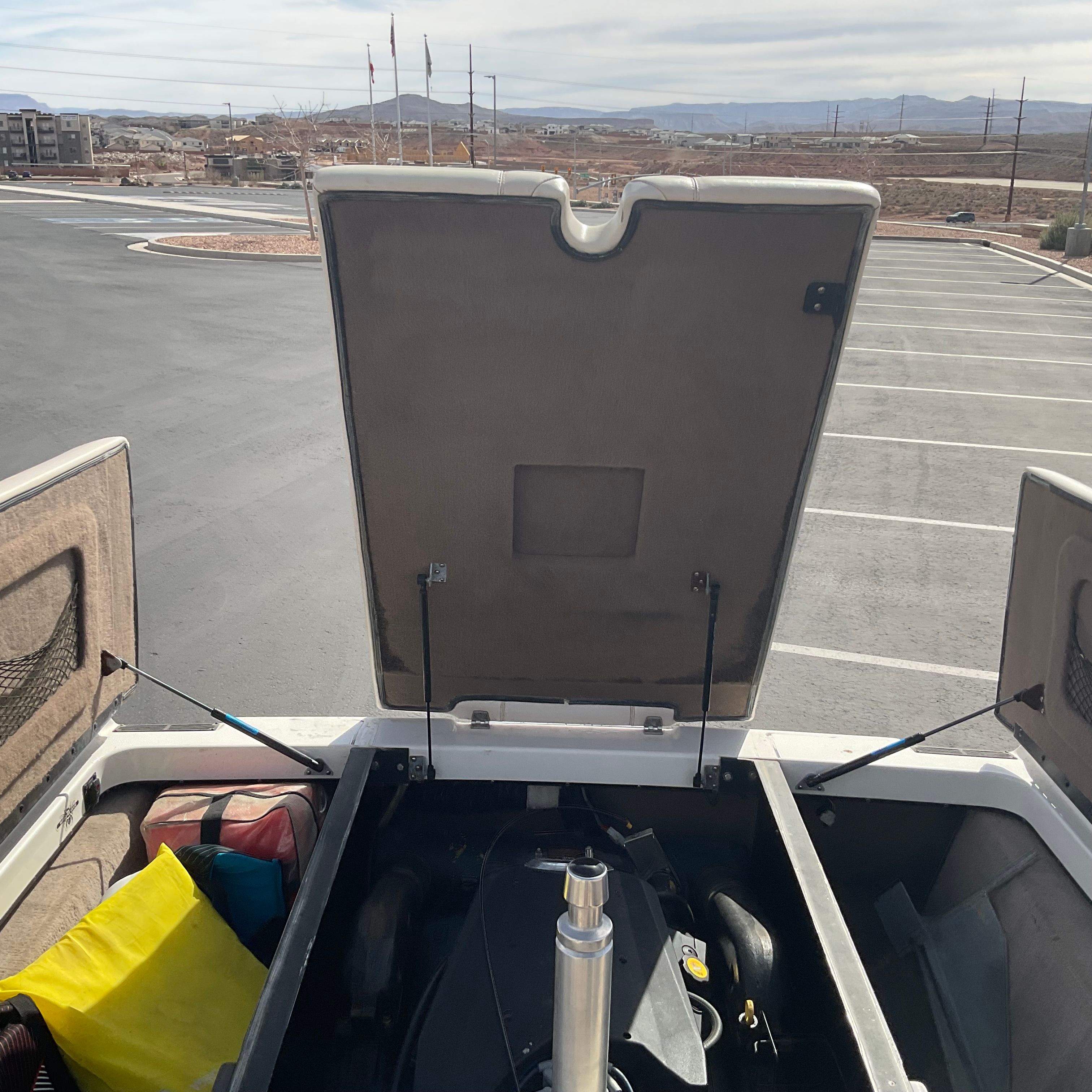 An open storage compartment on a boat with various items inside.