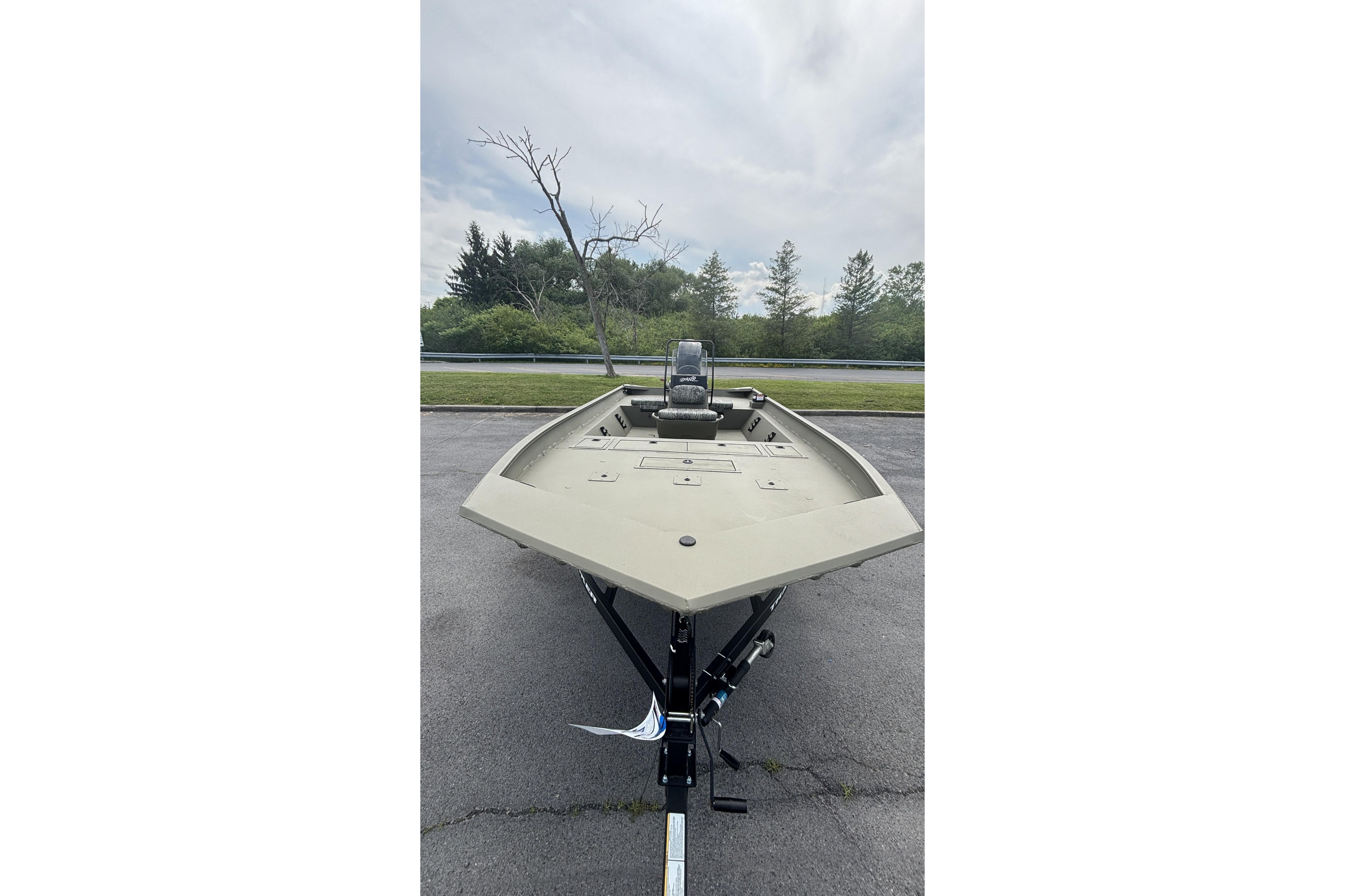 2026 Tracker Grizzly 2072 CC boat on trailer, parked outdoors.