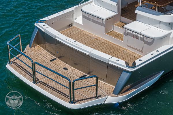 Riviera 645 SUV 2025 model yacht stern with teak deck and stainless steel railings.