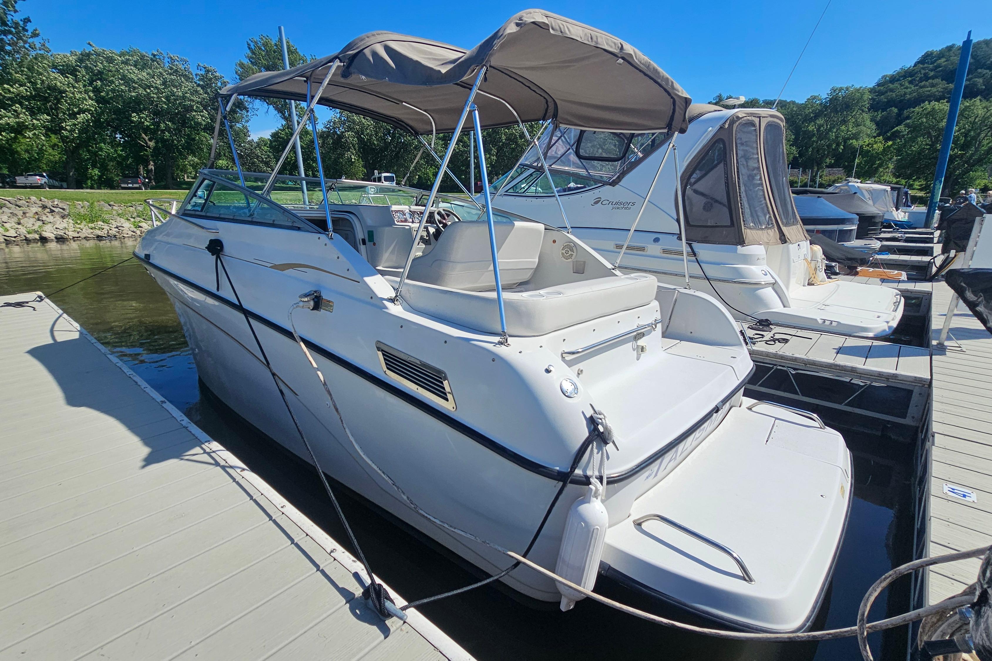 2000 Crownline 242 CR boat docked, featuring a canopy and sleek design.