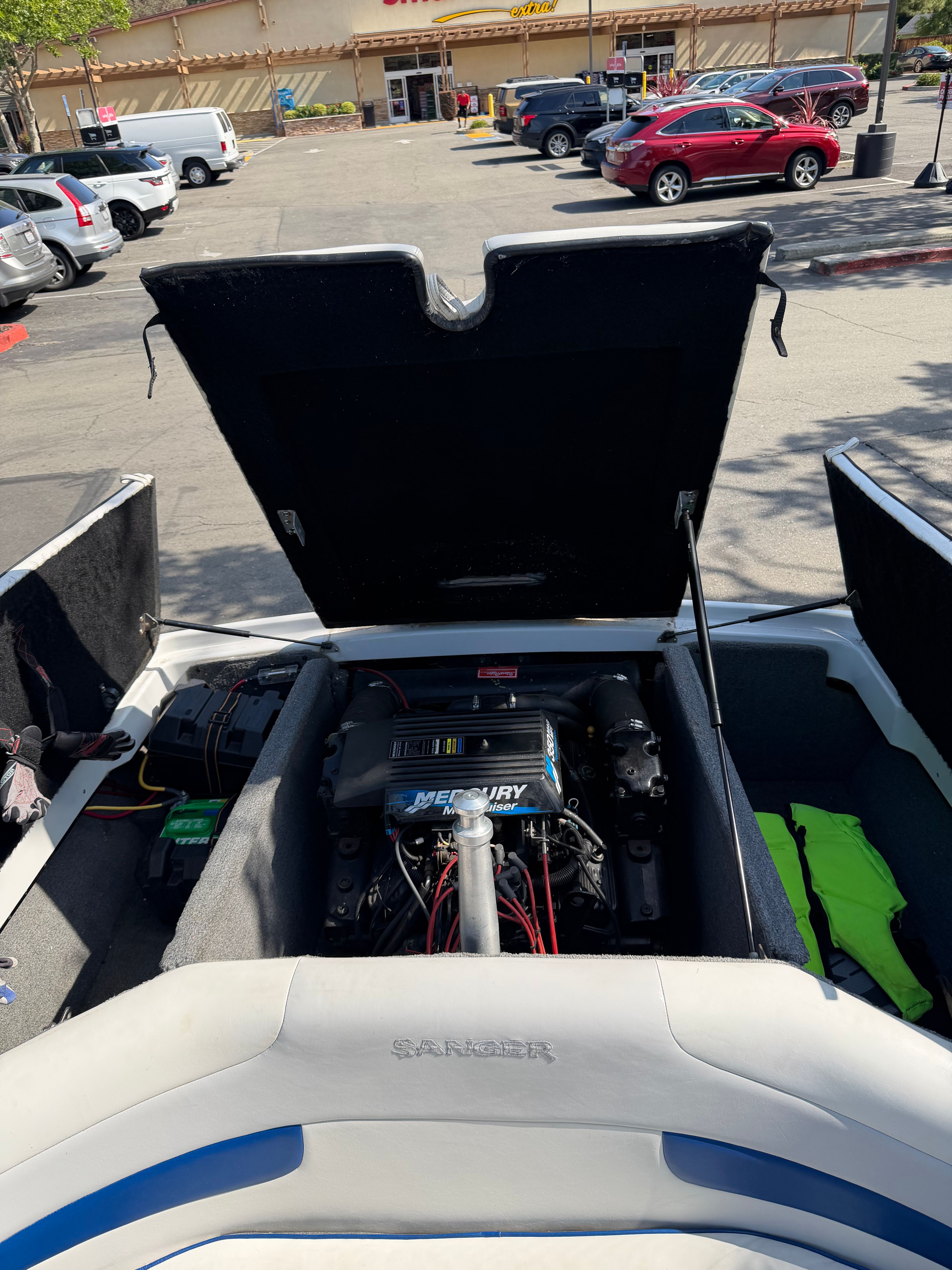 The engine compartment of a 2001 Sanger V210 is open, revealing a Mercury engine.