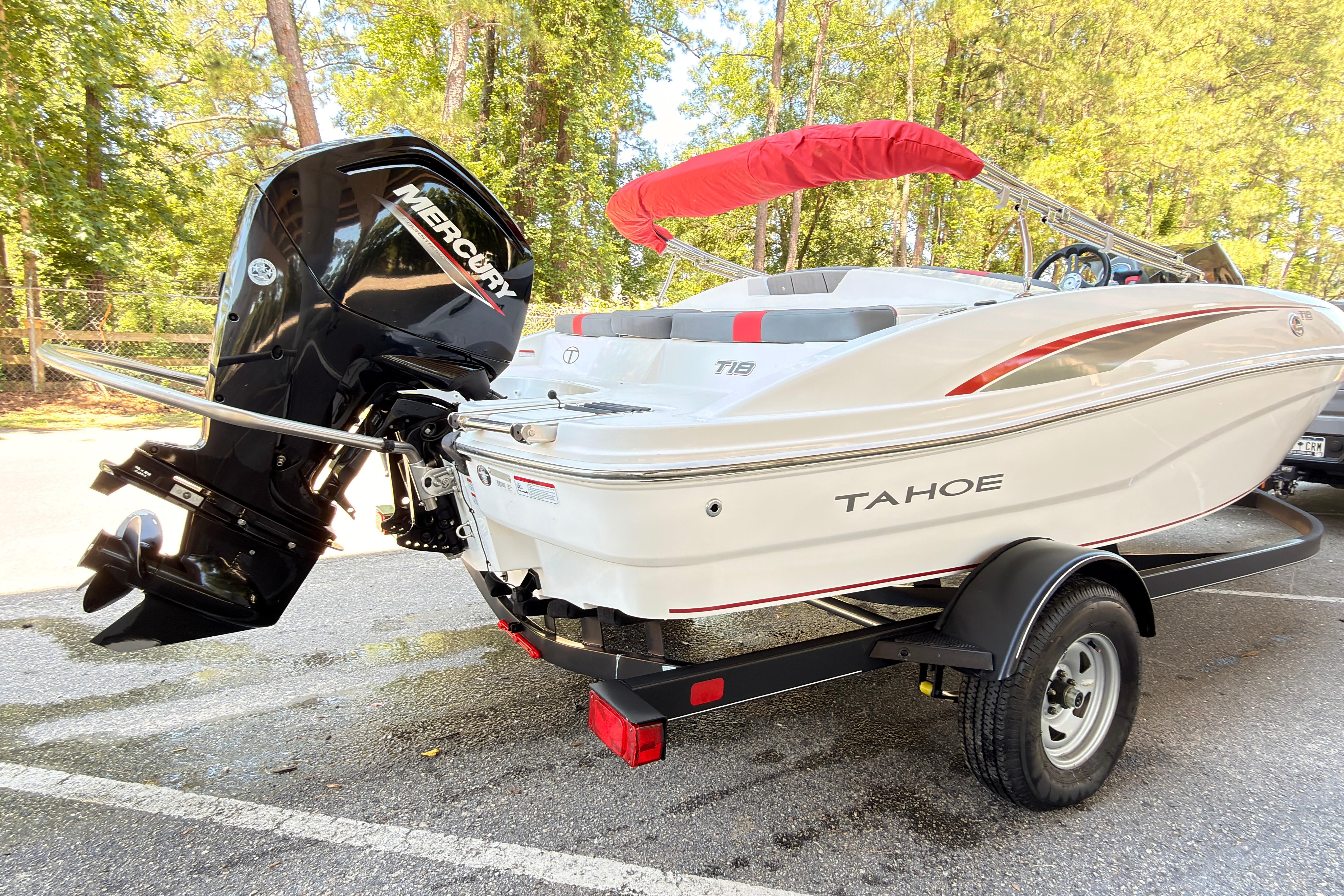 2022 Tahoe T18 boat with Mercury engine on trailer, parked outdoors.