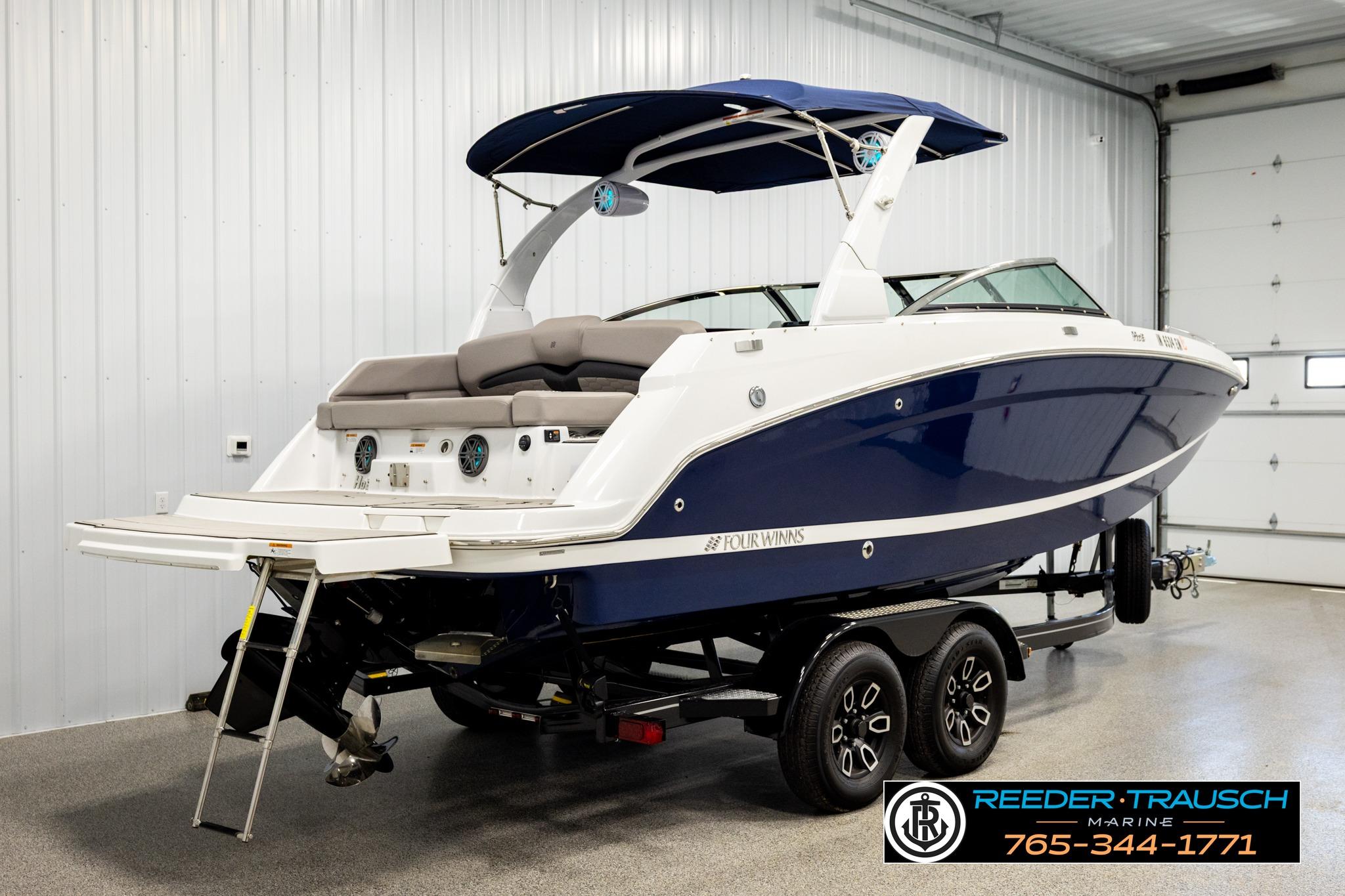 2024 FOURWINNS HD5 Surf boat in showroom, featuring sleek design and modern amenities.