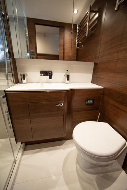 Luxurious bathroom in 2024 Princess V55 yacht with modern fixtures and wooden cabinetry.