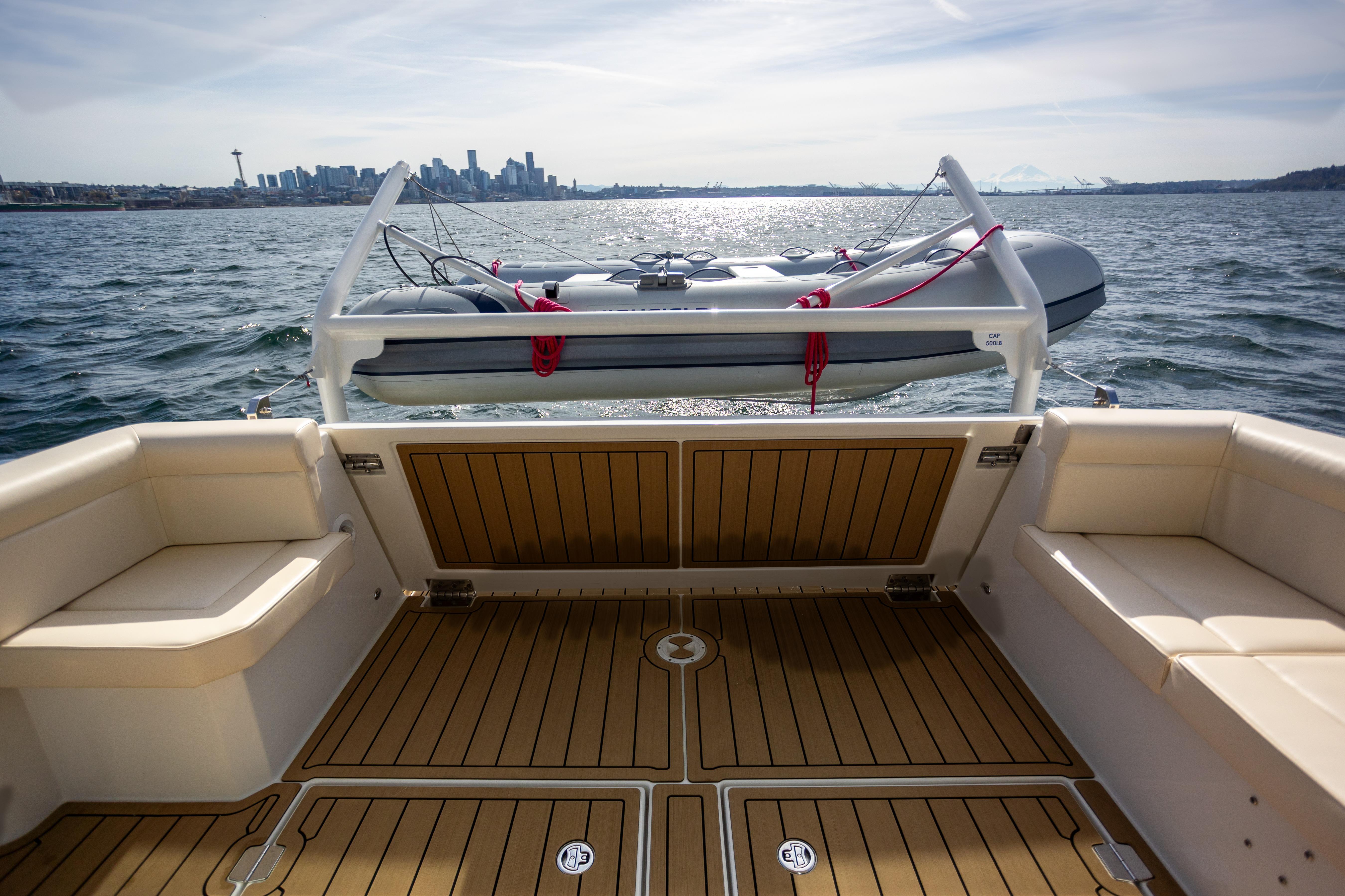 2024 Greenline 39 yacht deck with city skyline and inflatable boat in background.