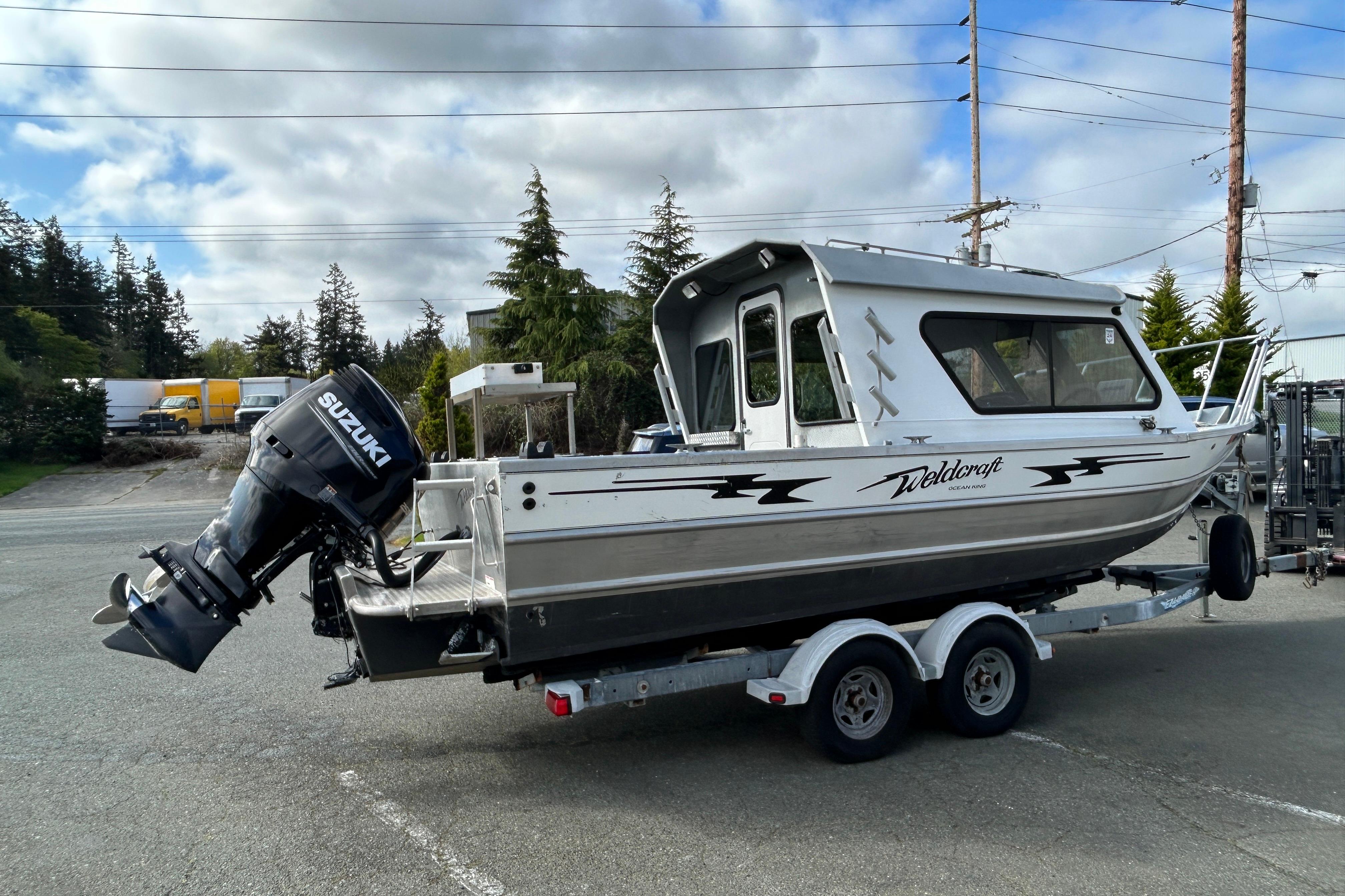 2010 Weldcraft 220 Ocean King boat on trailer with Suzuki outboard motor.