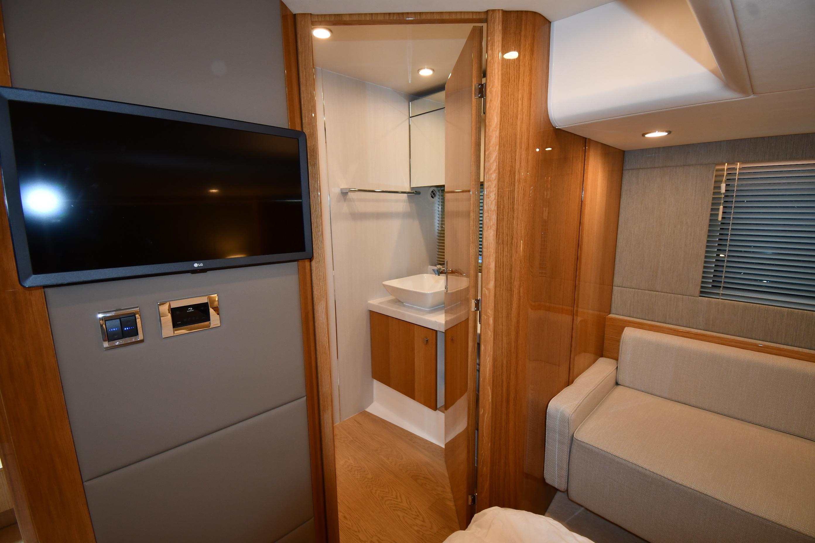 Luxurious interior of 2024 Fairline G50 Targa yacht with TV and modern bathroom.