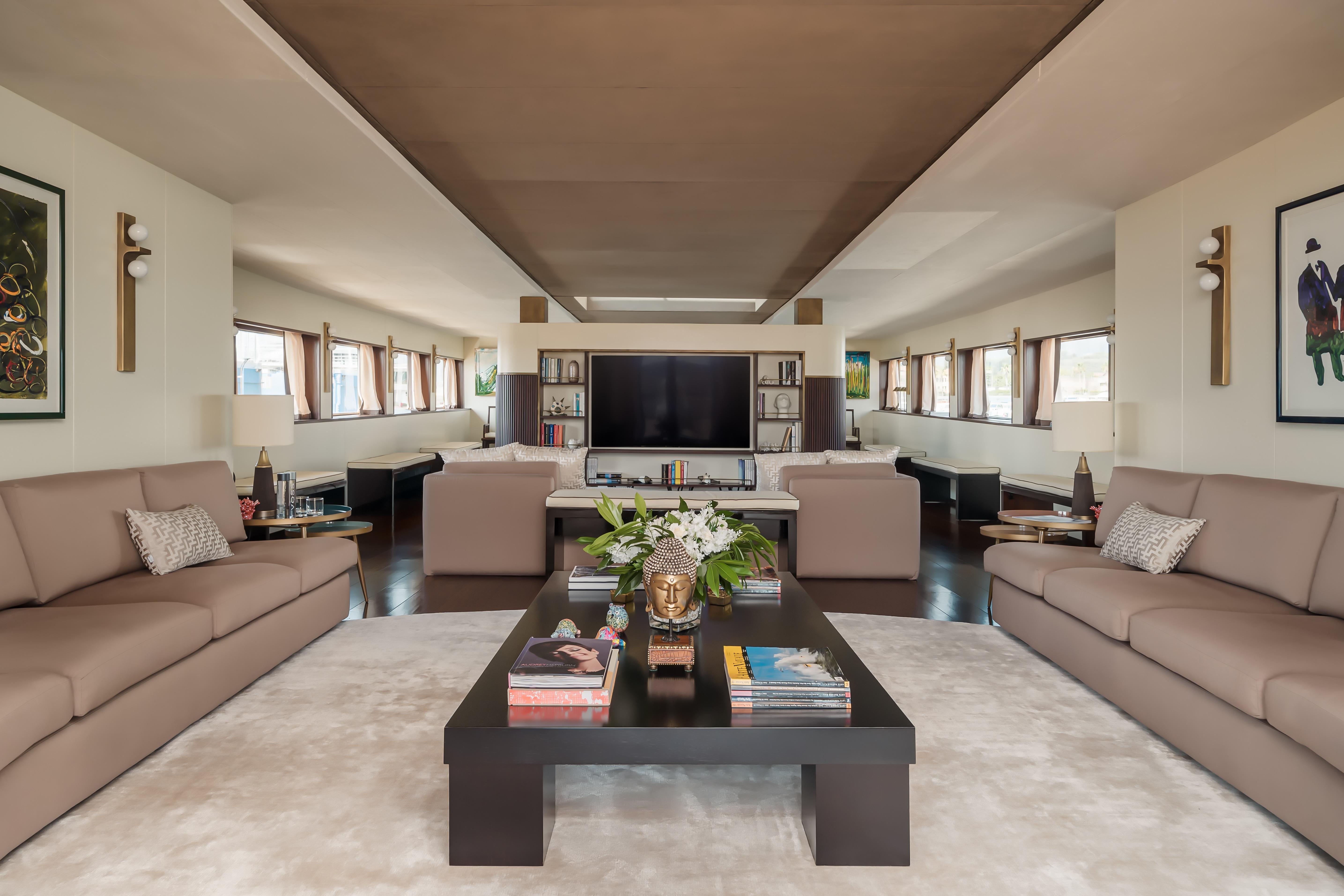 Luxurious living area in a 1956 custom converted tug, featuring elegant sofas and decor.