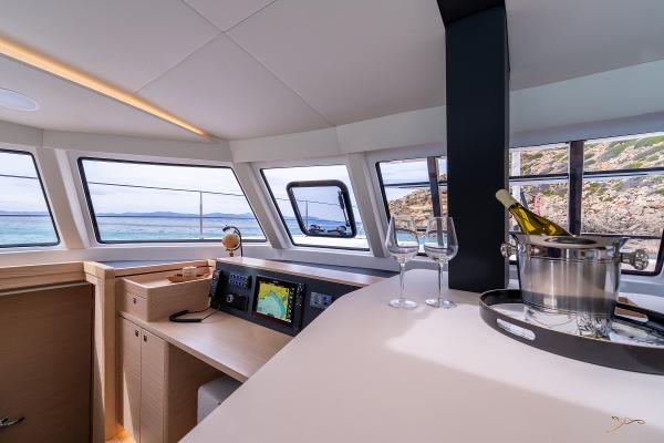 Luxurious interior of 2025 Nautitech 44 Open yacht with panoramic windows and wine setup.