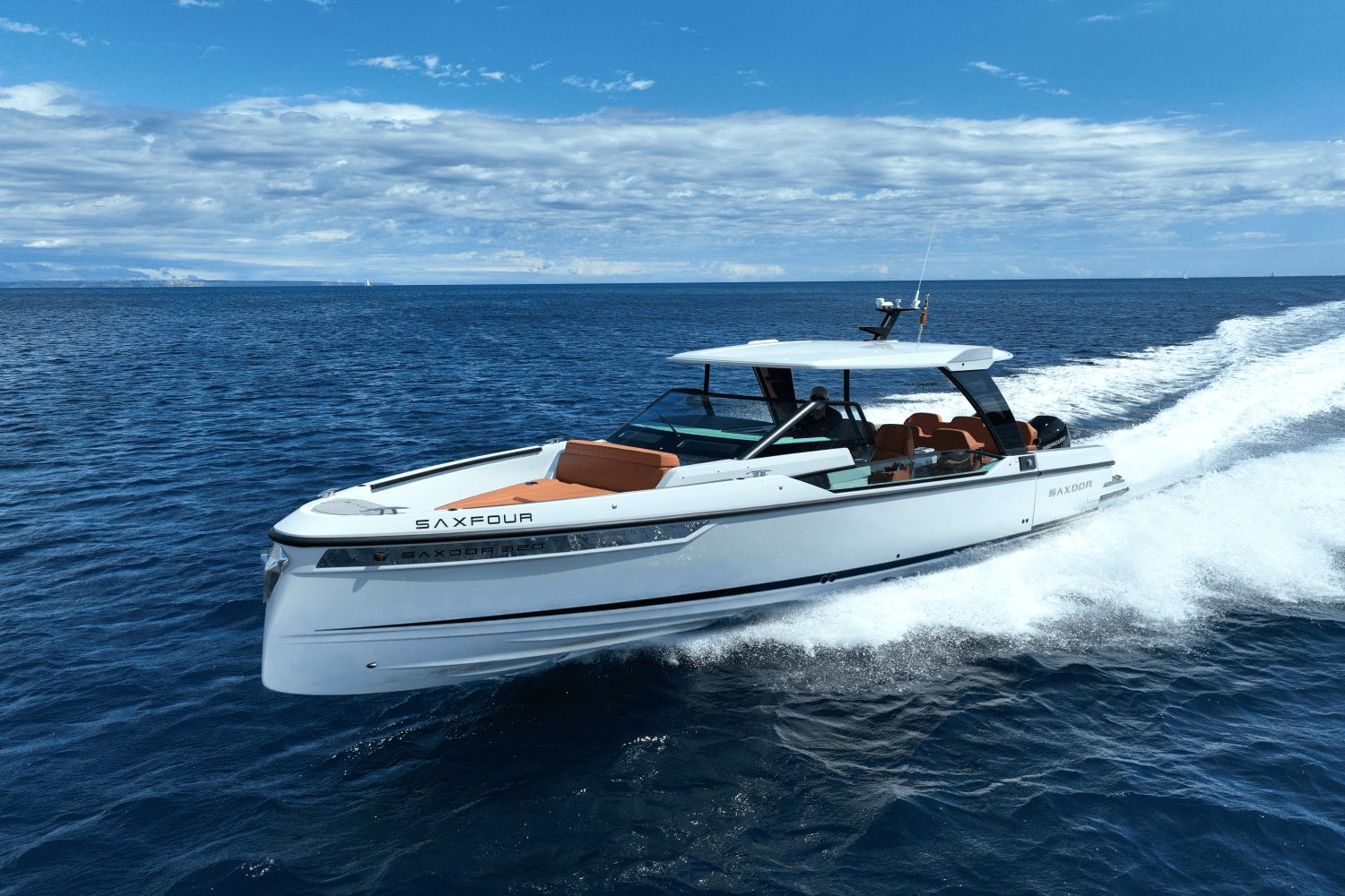 A Saxdor SX320 GTO boat speeds across the sea under a blue sky.