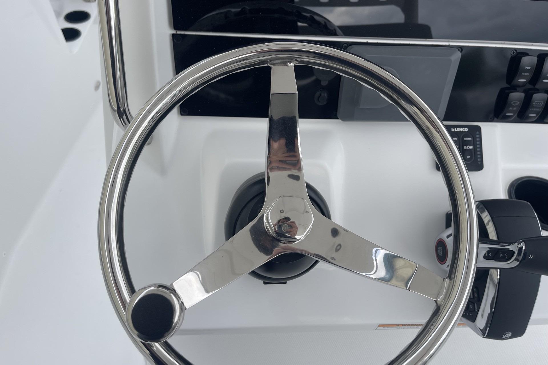 Steering wheel of 2026 Hurricane Center Console 24 OB boat, featuring modern controls.
