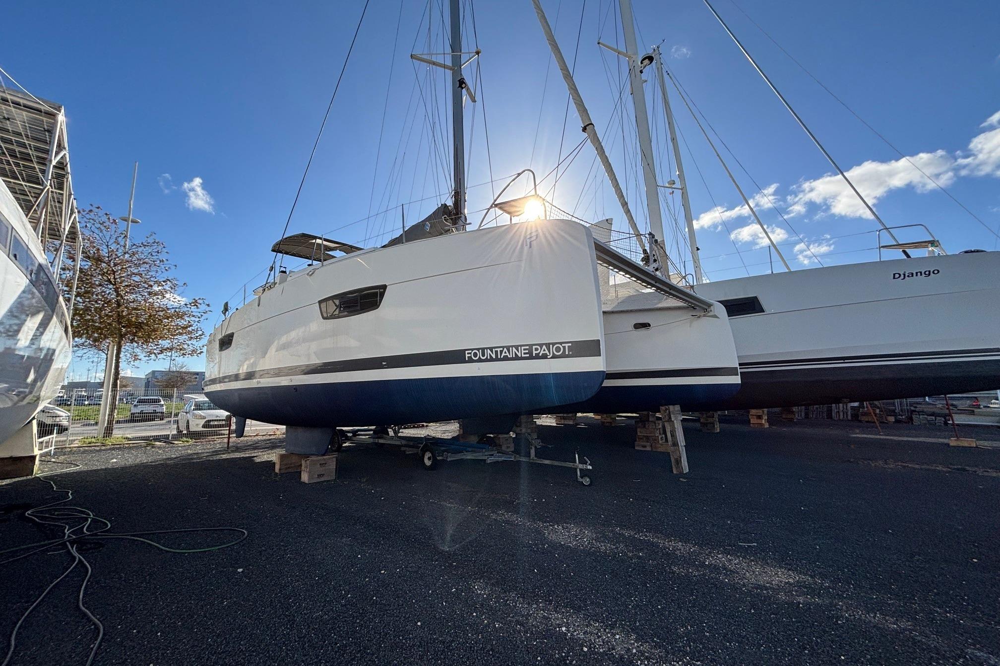 2021 Fountaine Pajot Astrea 42 catamaran on land, sunlit, with clear blue sky.