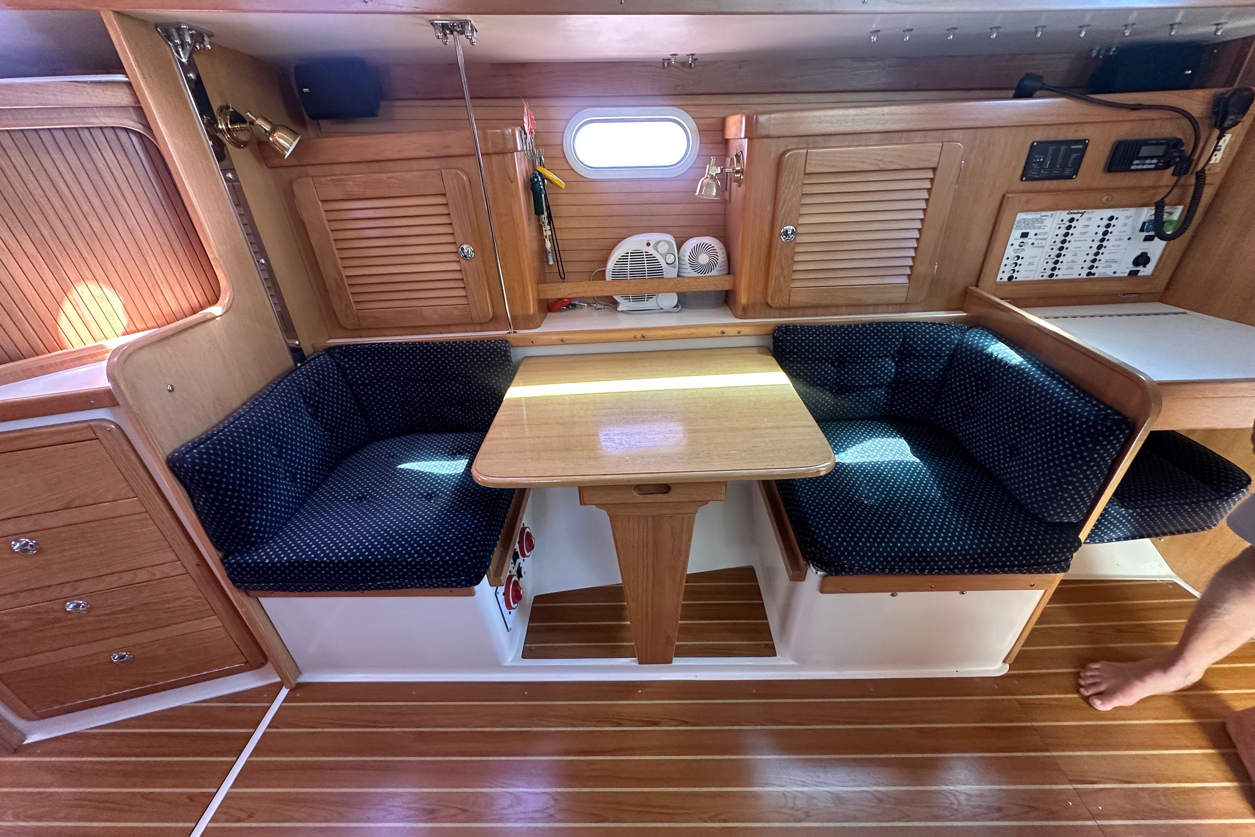 Interior of 2005 Catalina 36 MkII sailboat with wooden cabinetry and cozy seating area.
