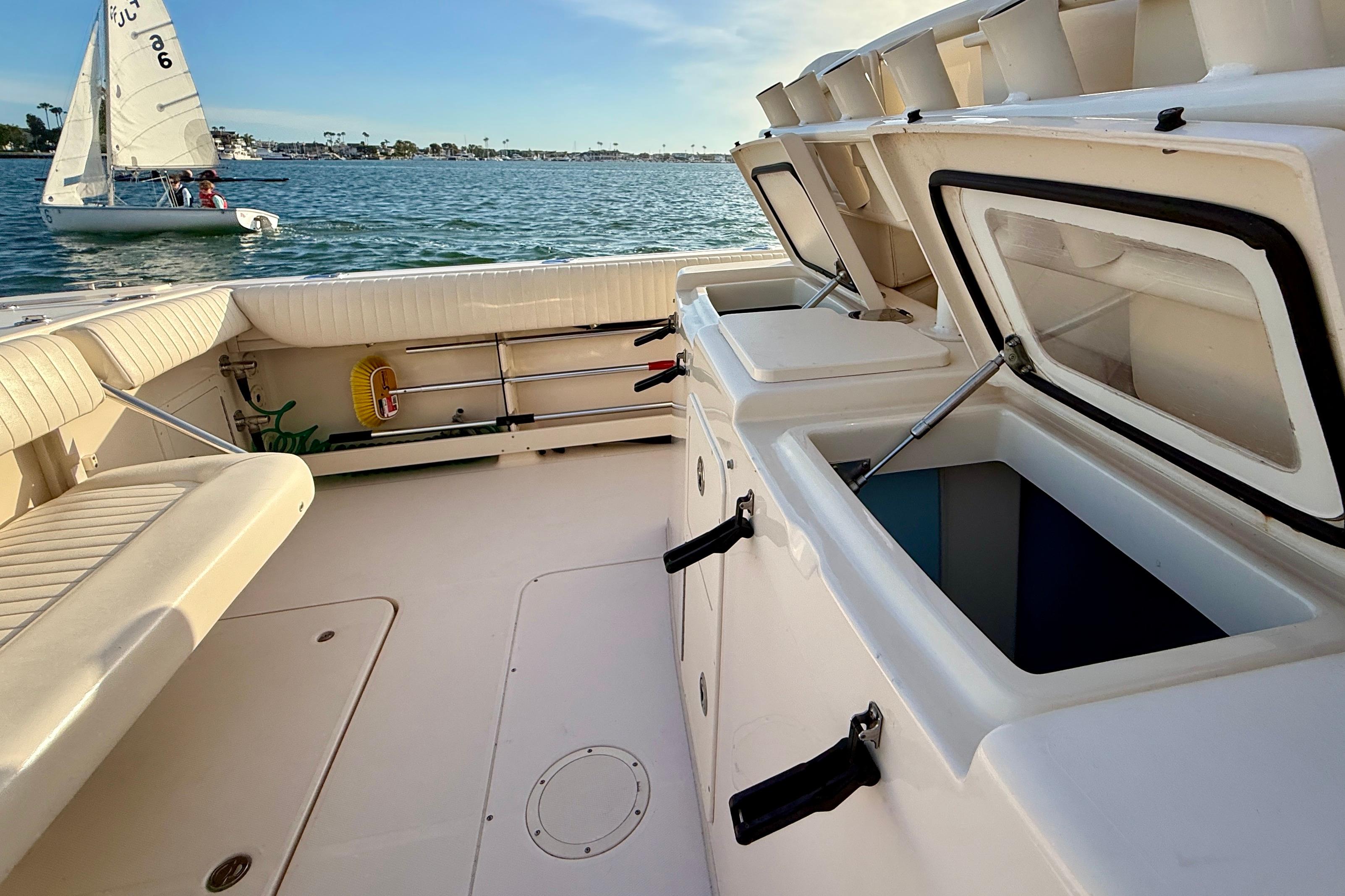 2012 Grady-White Canyon 336 boat interior with open storage compartments, docked near sailboat.