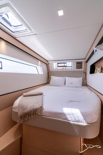 Luxurious cabin interior of 2025 Nautitech 44 Open catamaran, featuring a cozy bed and modern design.