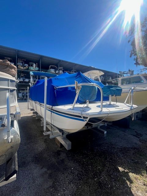 A 2017 Beachcat Catamaran on a trailer, covered with a blue tarp, under clear skies.