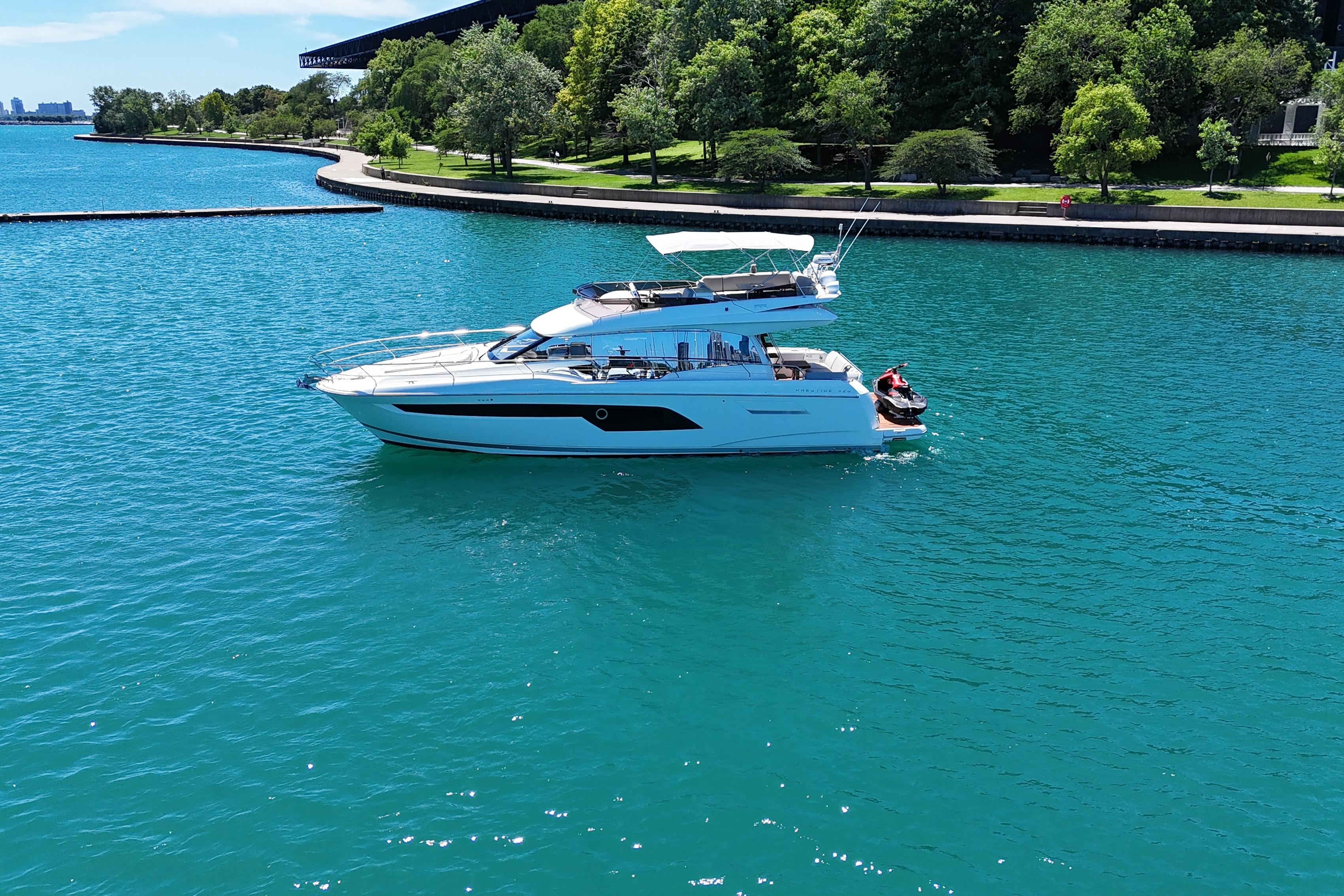 Luxury 2022 Prestige 520 yacht cruising on a serene, turquoise lake.