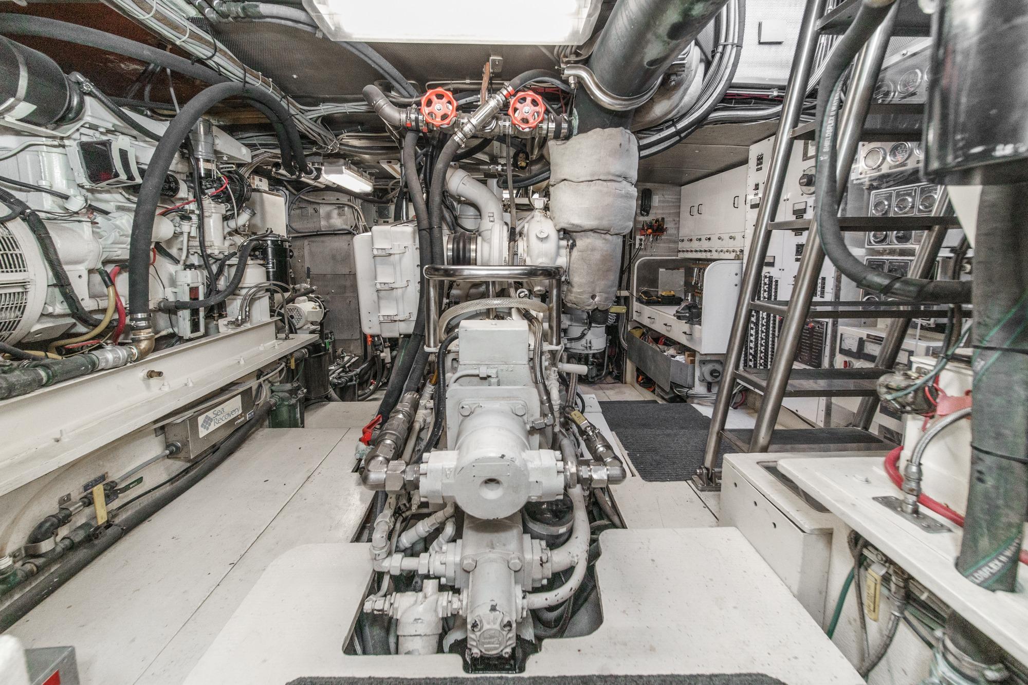 Engine room of a 1990 Seaton Long Range Cruiser, showcasing complex machinery and piping.