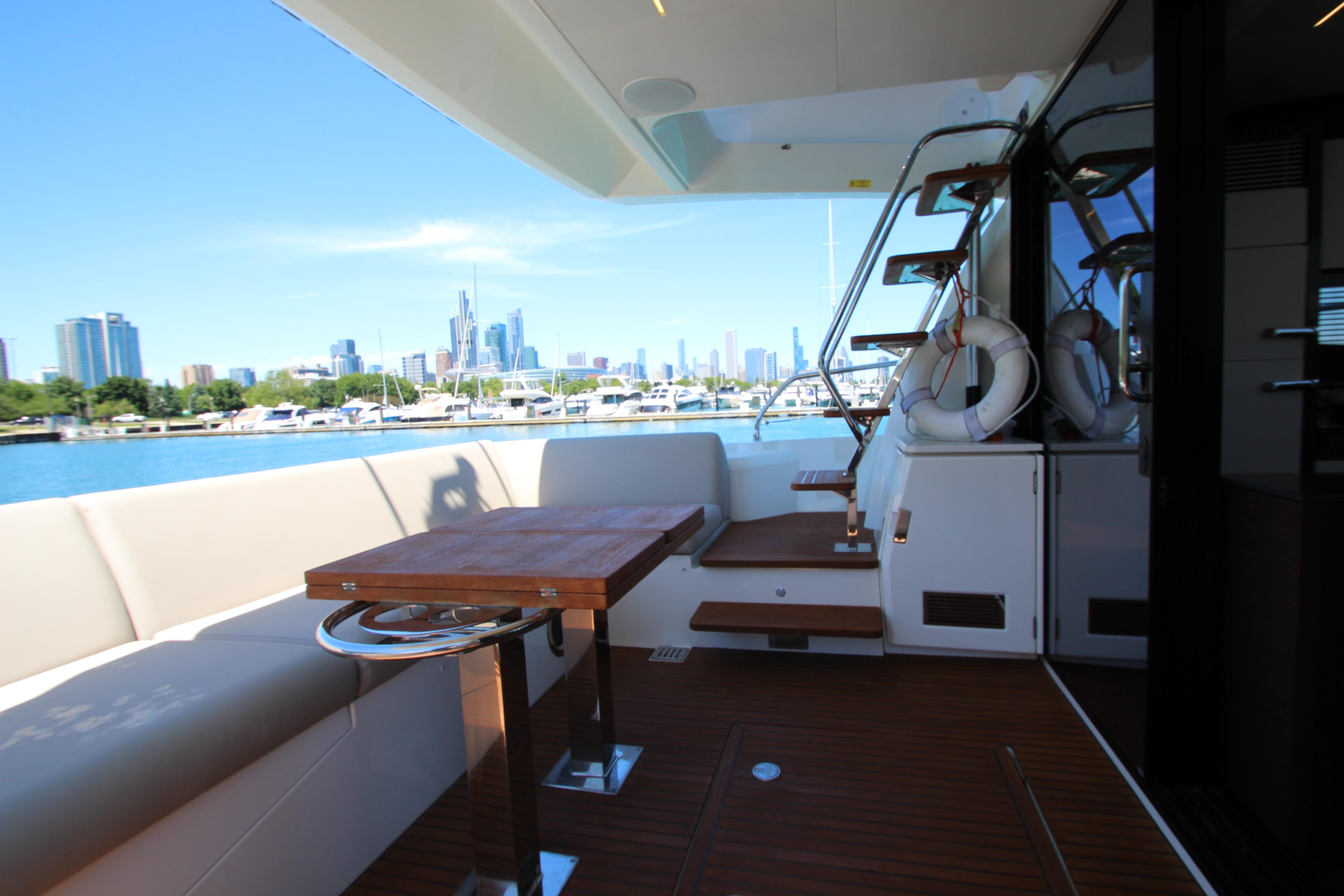 Luxurious 2022 Prestige 520 yacht deck with city skyline view.