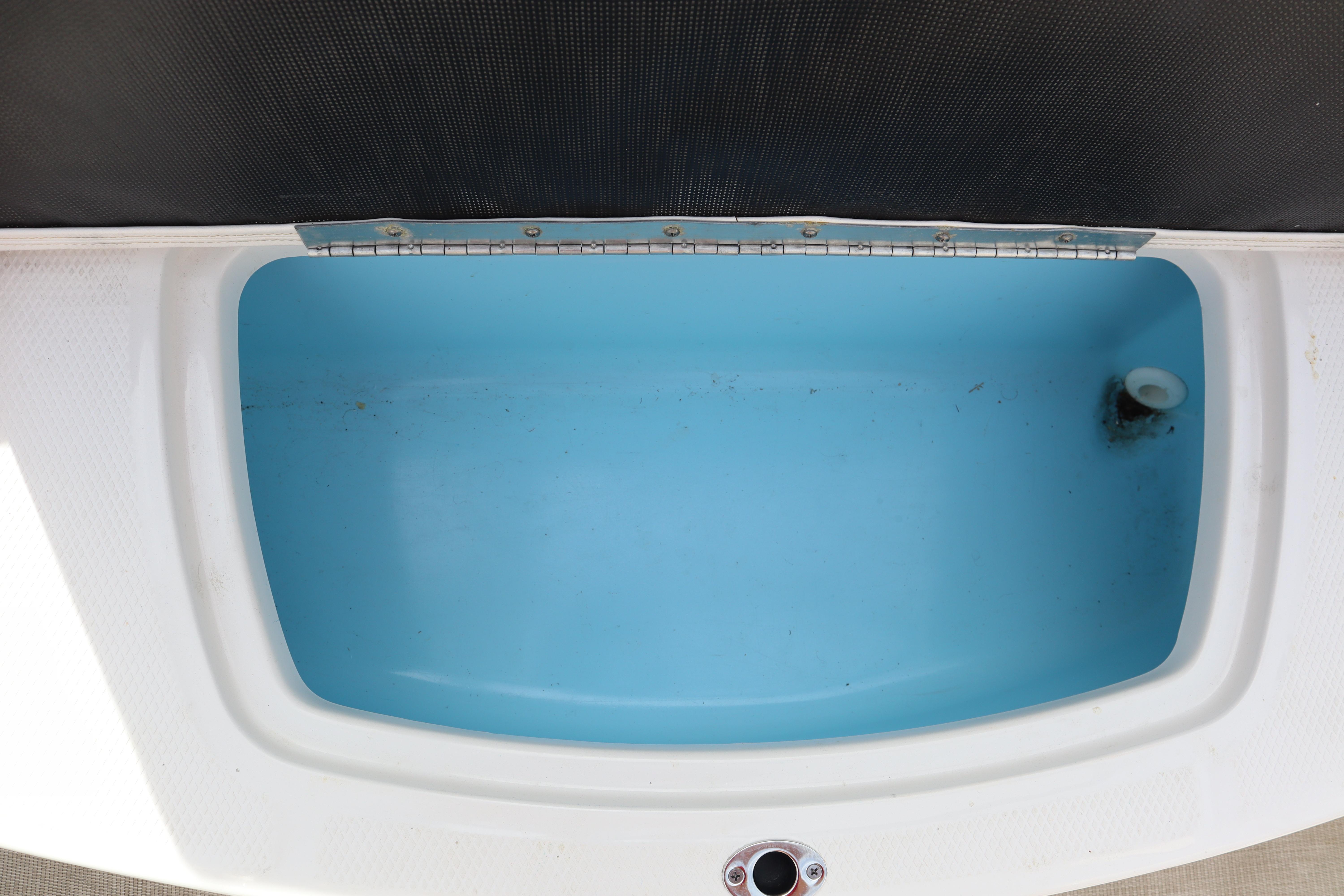 Open storage compartment in 2021 Chaparral 21 SSi boat, featuring a blue interior.