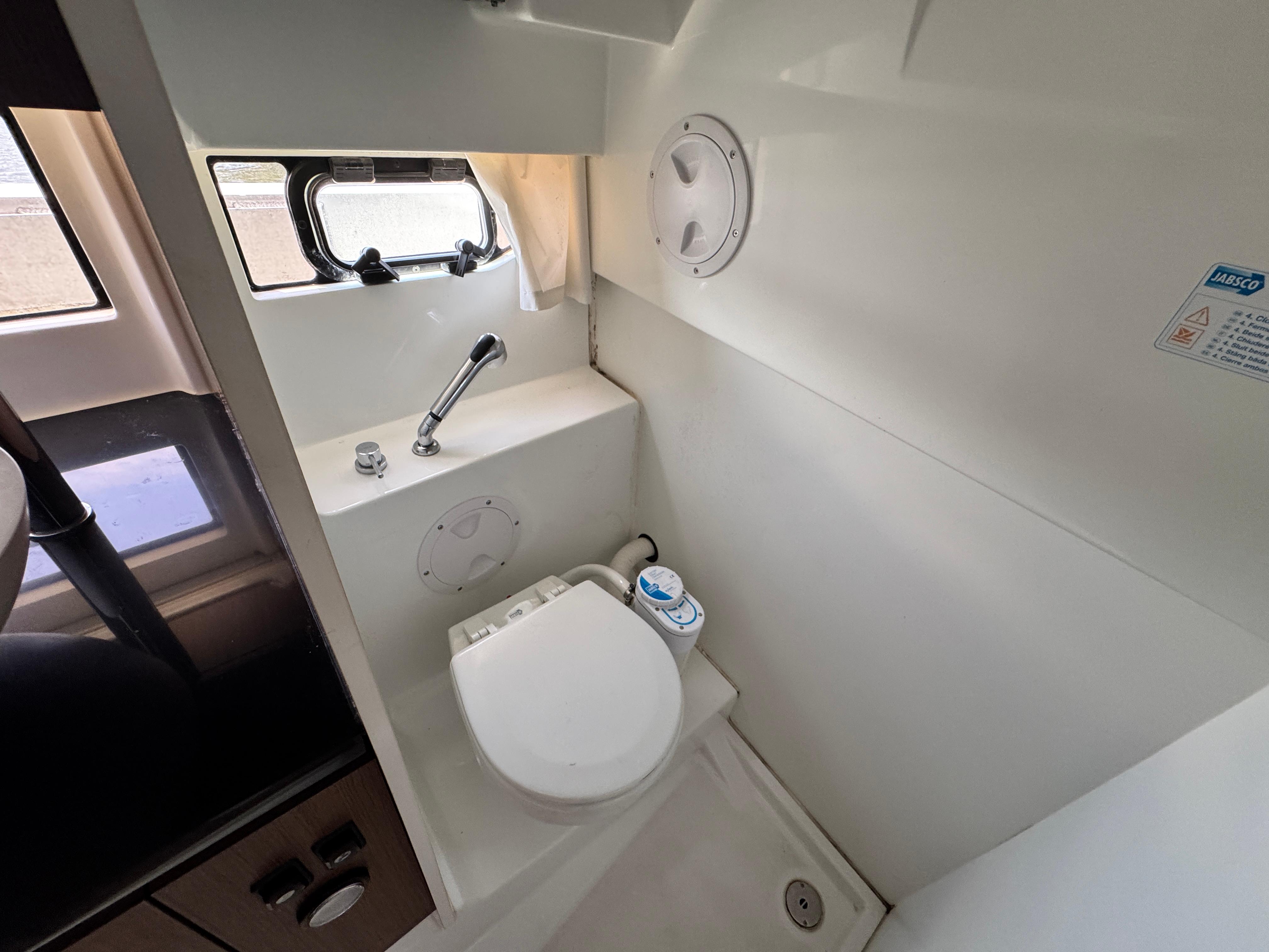 2022 Beneteau Flyer 9 SUNdeck bathroom with compact toilet and window.