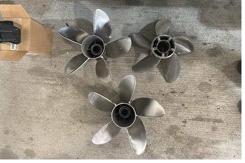 Three stainless steel boat propellers on concrete floor, suitable for 2004 Outerlimits 42 Legacy.