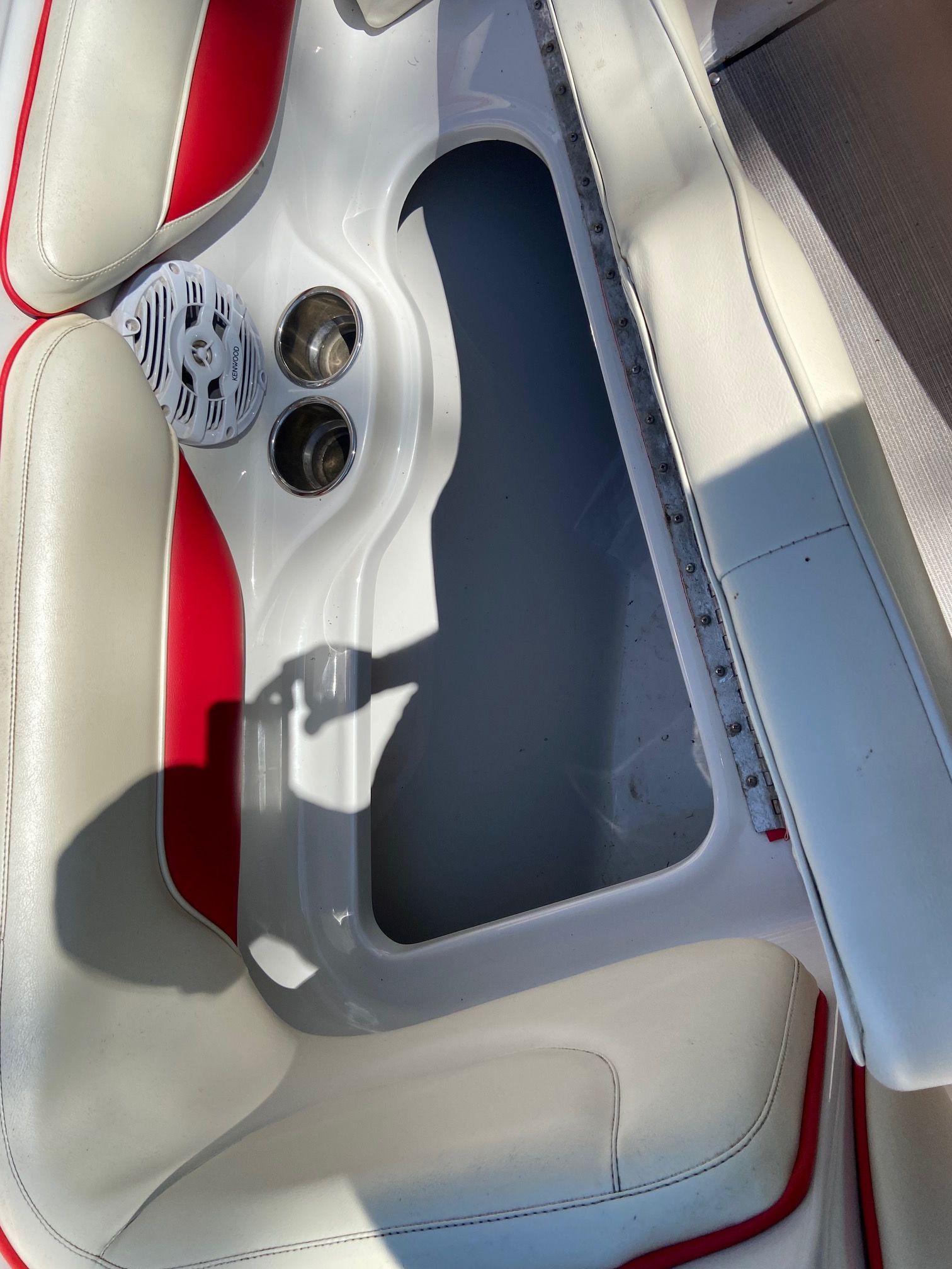 Close-up of a boat interior with white and red upholstery and speakers.