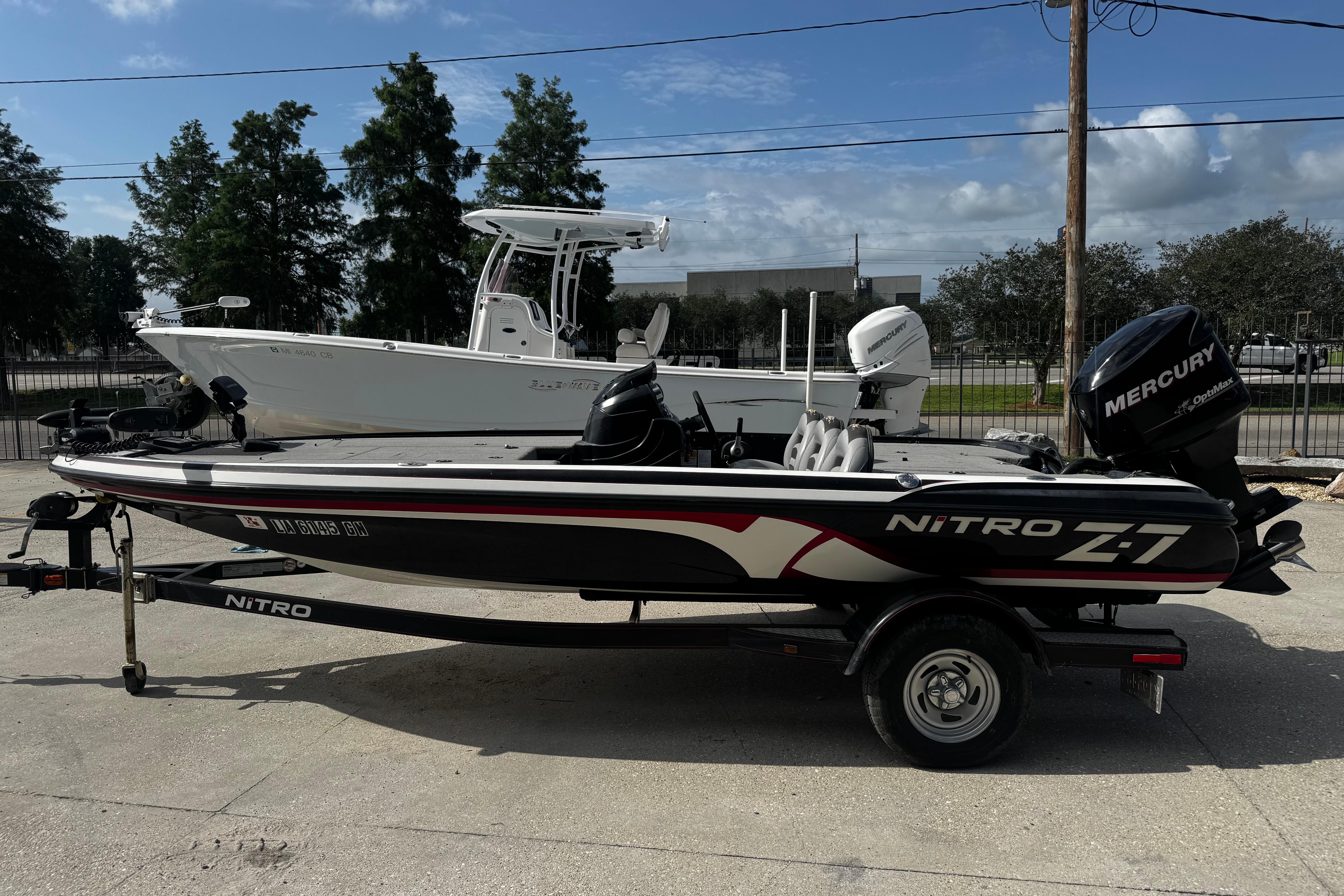 2012 Nitro Z-7 boat with Mercury engine on trailer, parked outdoors.