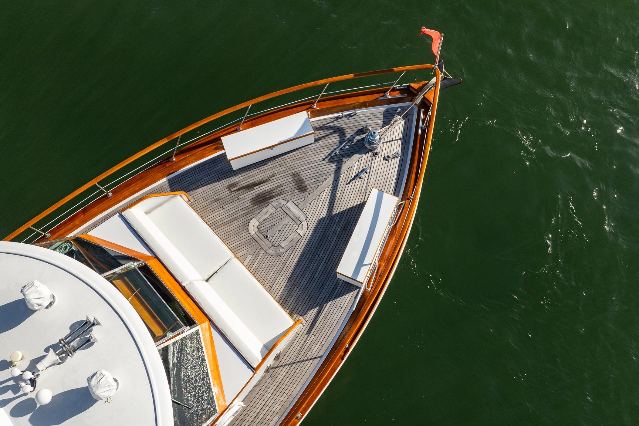 Aerial view of 1972 Trumpy 72 Motor Yacht deck with seating, on calm water.