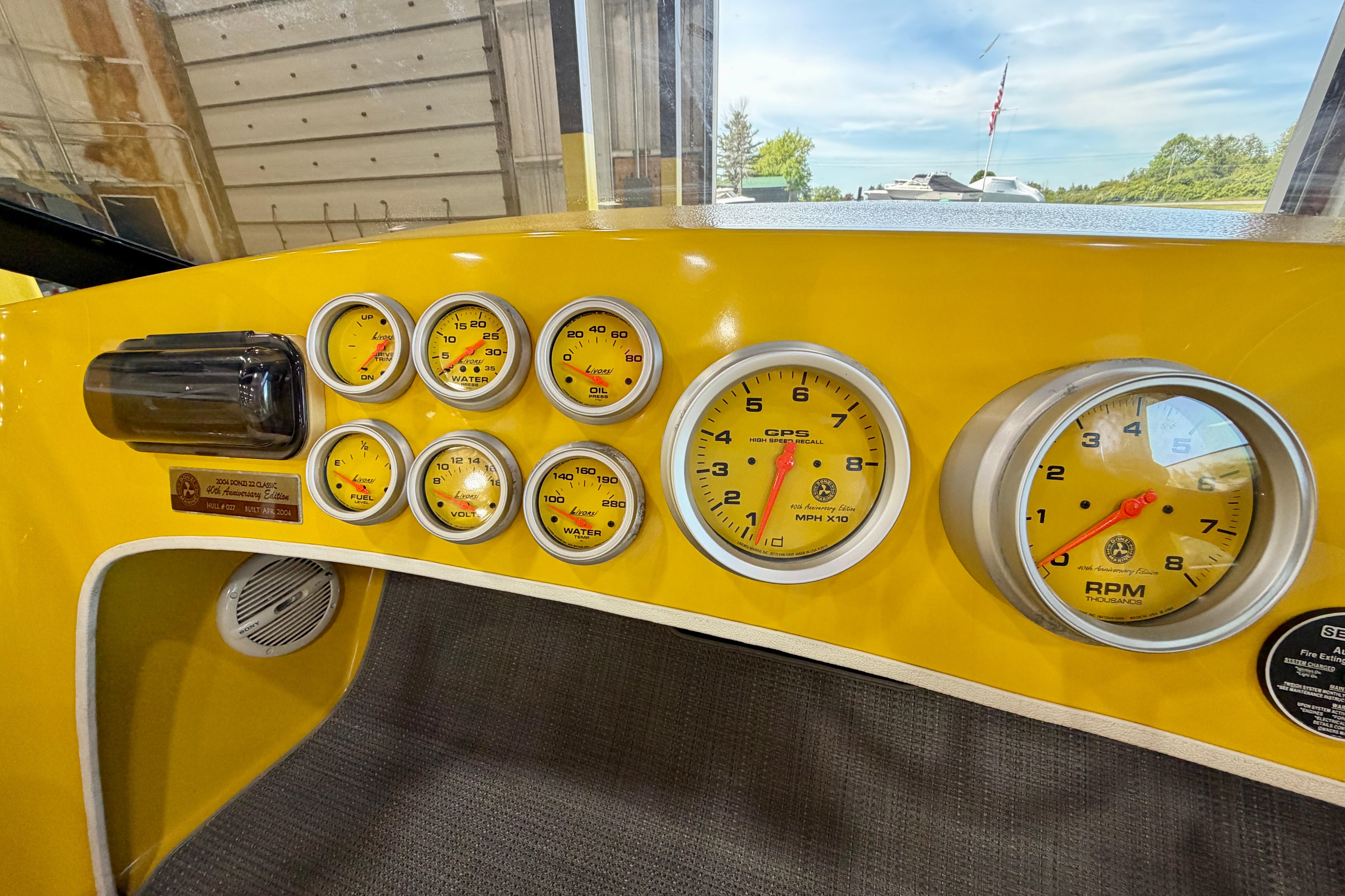 Dashboard of a 2004 Donzi 22 Classic boat with yellow gauges and controls.