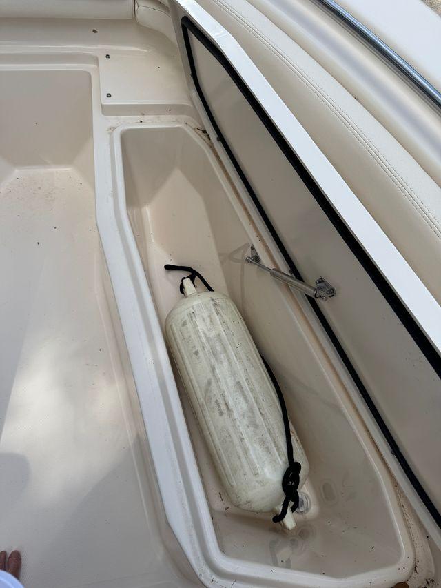 2017 Grady-White Fisherman 257 boat storage compartment with a white fender inside.