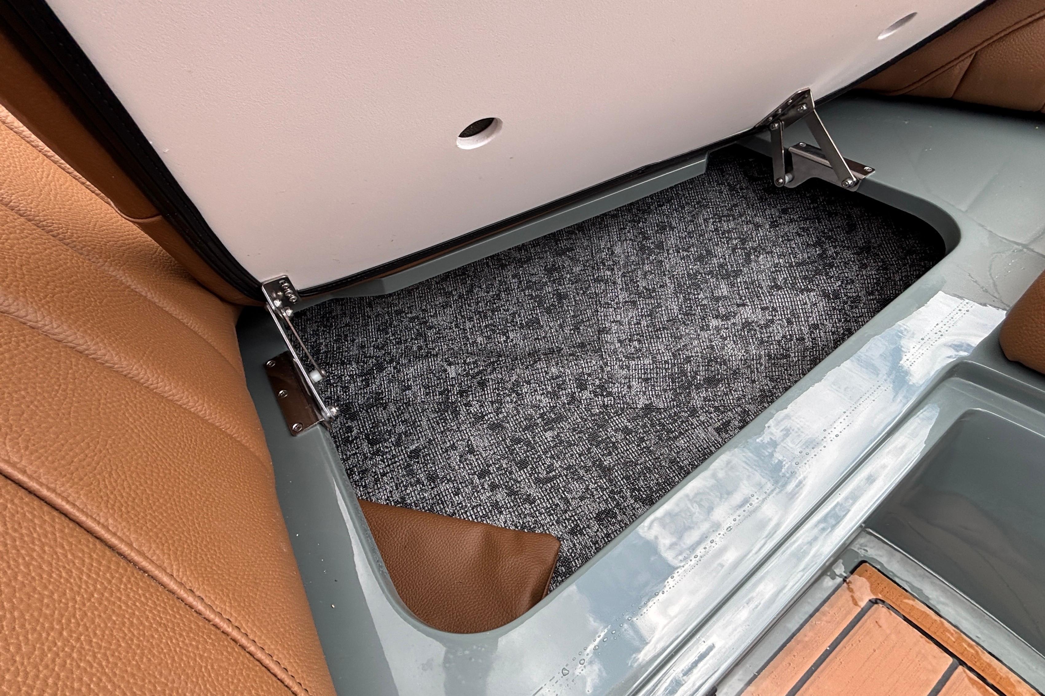 Storage compartment in 2026 MB B52 23 Classic boat with brown leather seating.