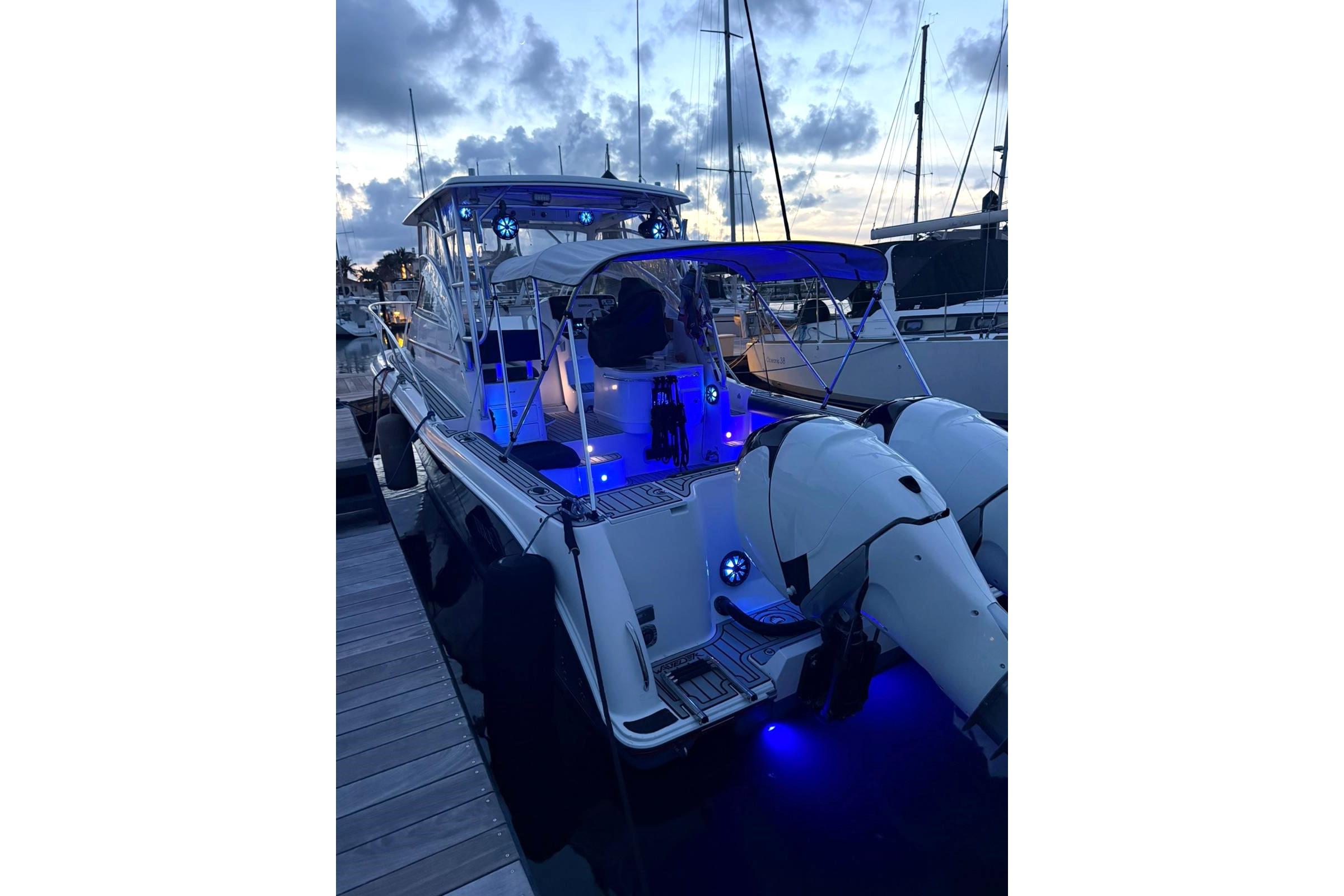 2006 Pro-Line 32 Express boat docked at sunset with blue LED lights.
