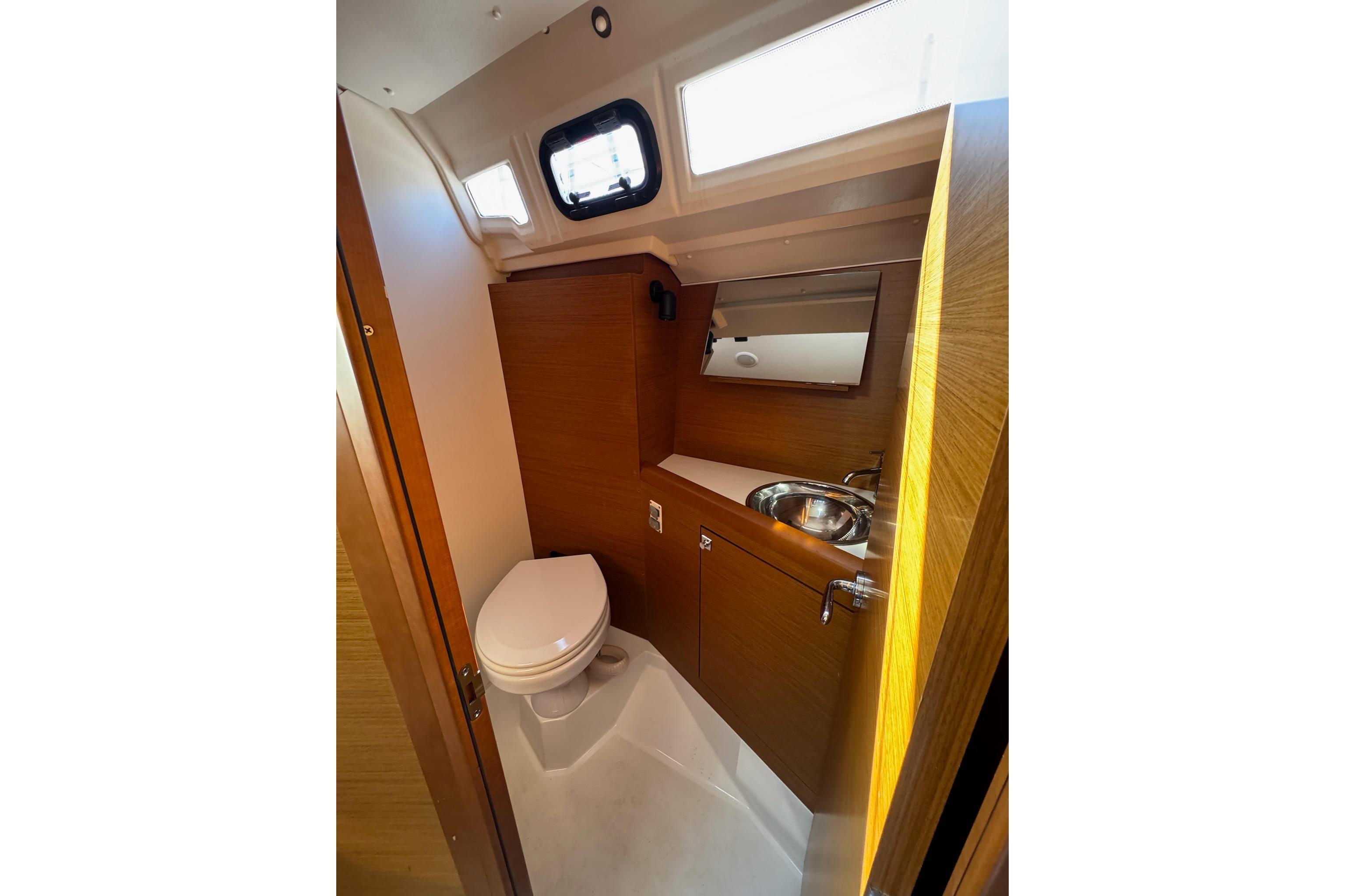 Modern bathroom in 2020 Jeanneau Sun Odyssey 349 yacht, featuring toilet and sink.