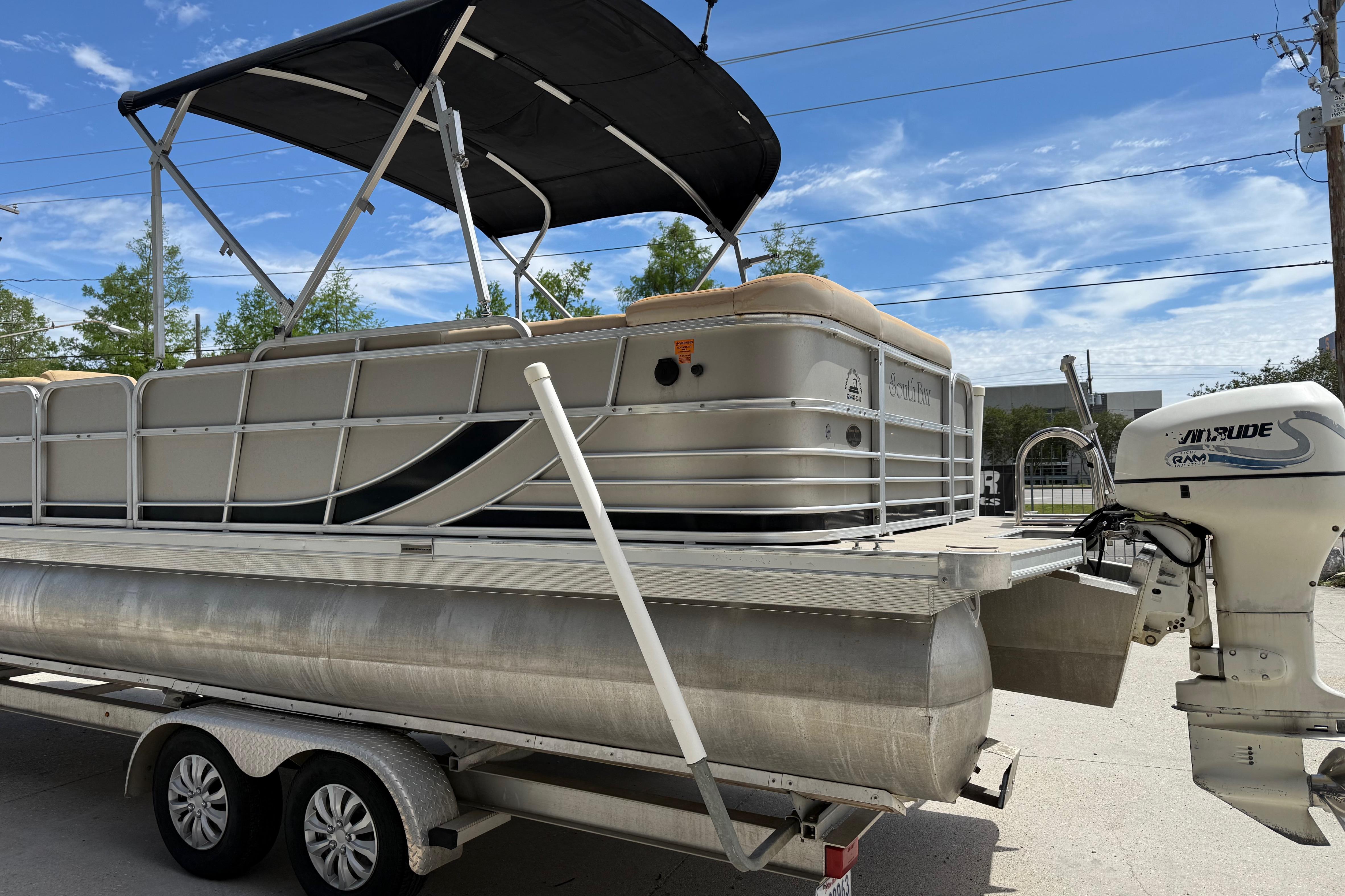 2012 South Bay 522 CR pontoon boat on trailer with Evinrude outboard motor.