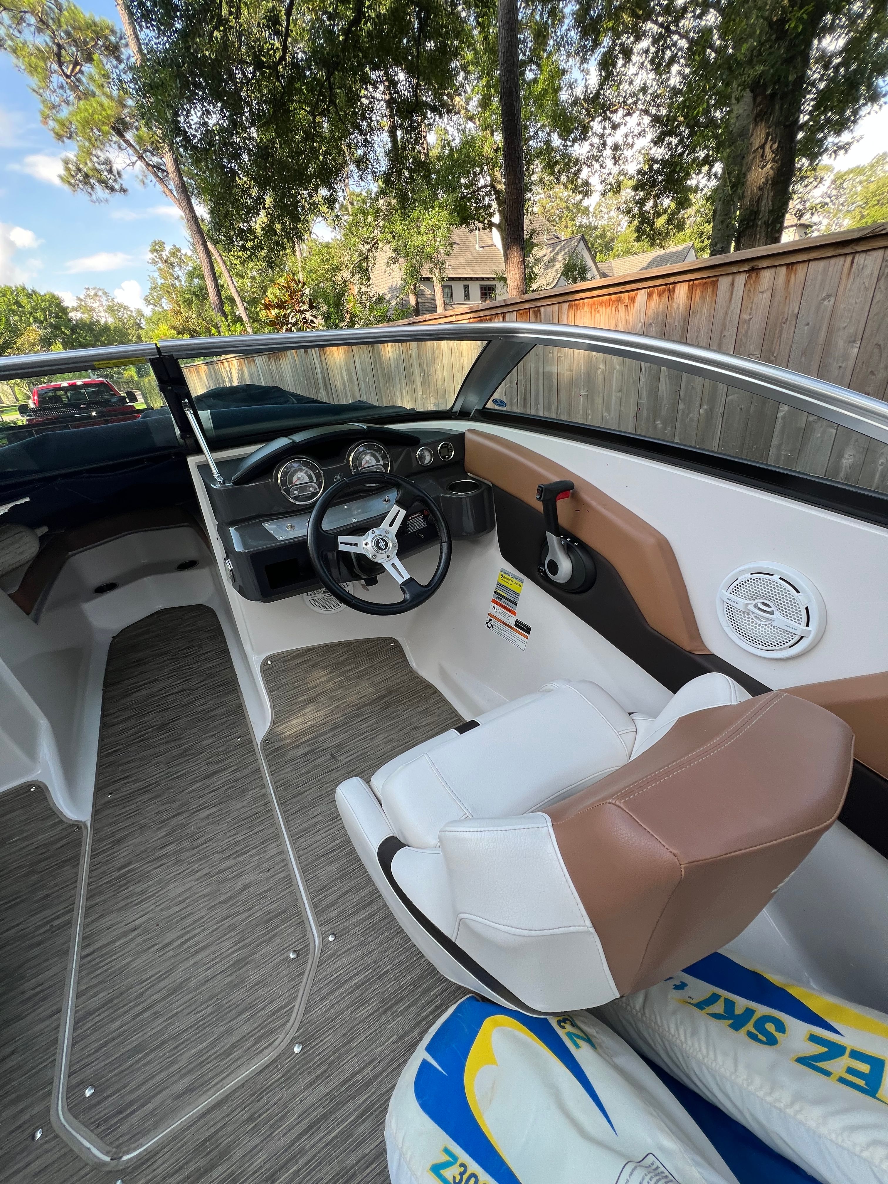 Interior of a 2017 Four Winns H230 boat with steering console.