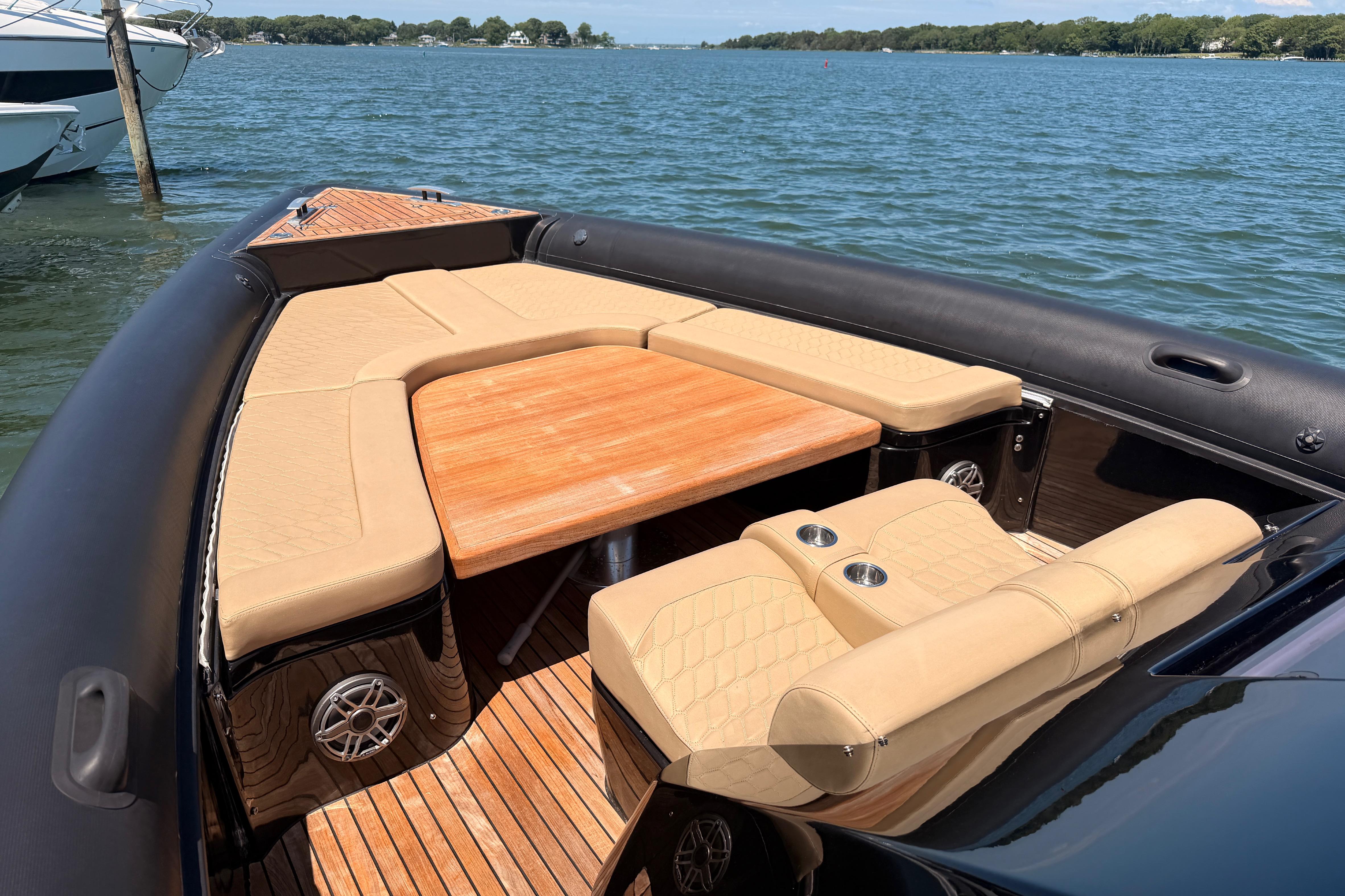 Luxurious 2023 Skipper-BSK 42NC boat interior with beige seating and wooden table.